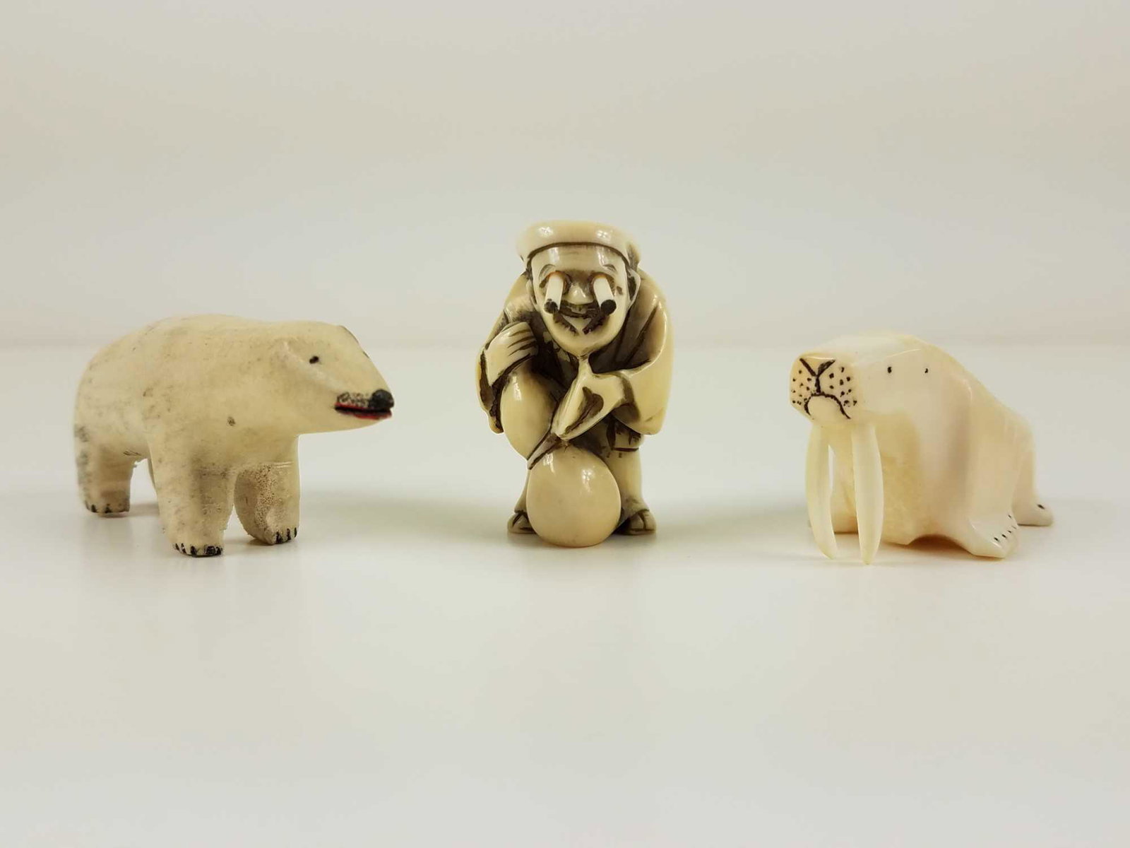 Three (3) Bone Carvings: This is a lot of three (3) animal bone carvings. Includes: One (1) carving of a polar bear, signed on the bottom by Alvey Shaaloak. MEASUREMENTS: 3.25" x 1.25" x .75" One (1) is a carving of a walrus.