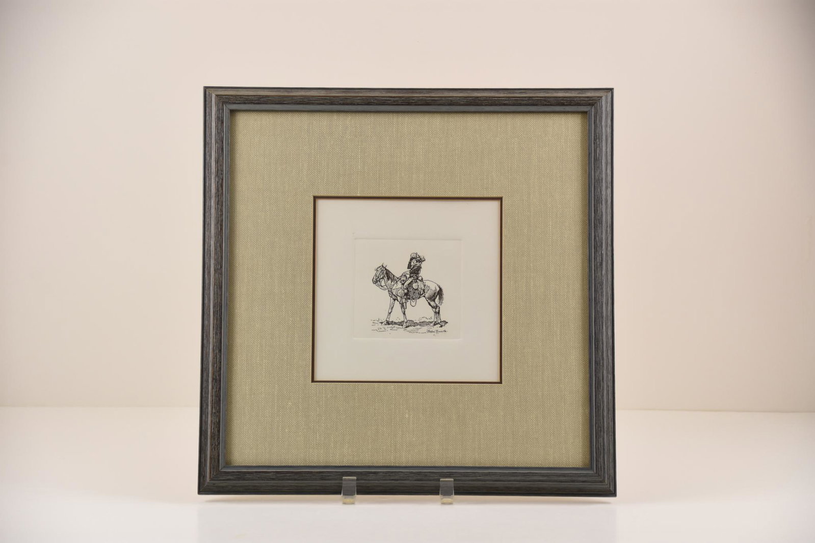 Frederic Remington Etching Print "A Pull at the: Framed and matted Frederic Remington etching print titled "A Pull at the Canteen". MEASUREMENTS: 15.5" x 15.5" for frame. CONDITION: Very good