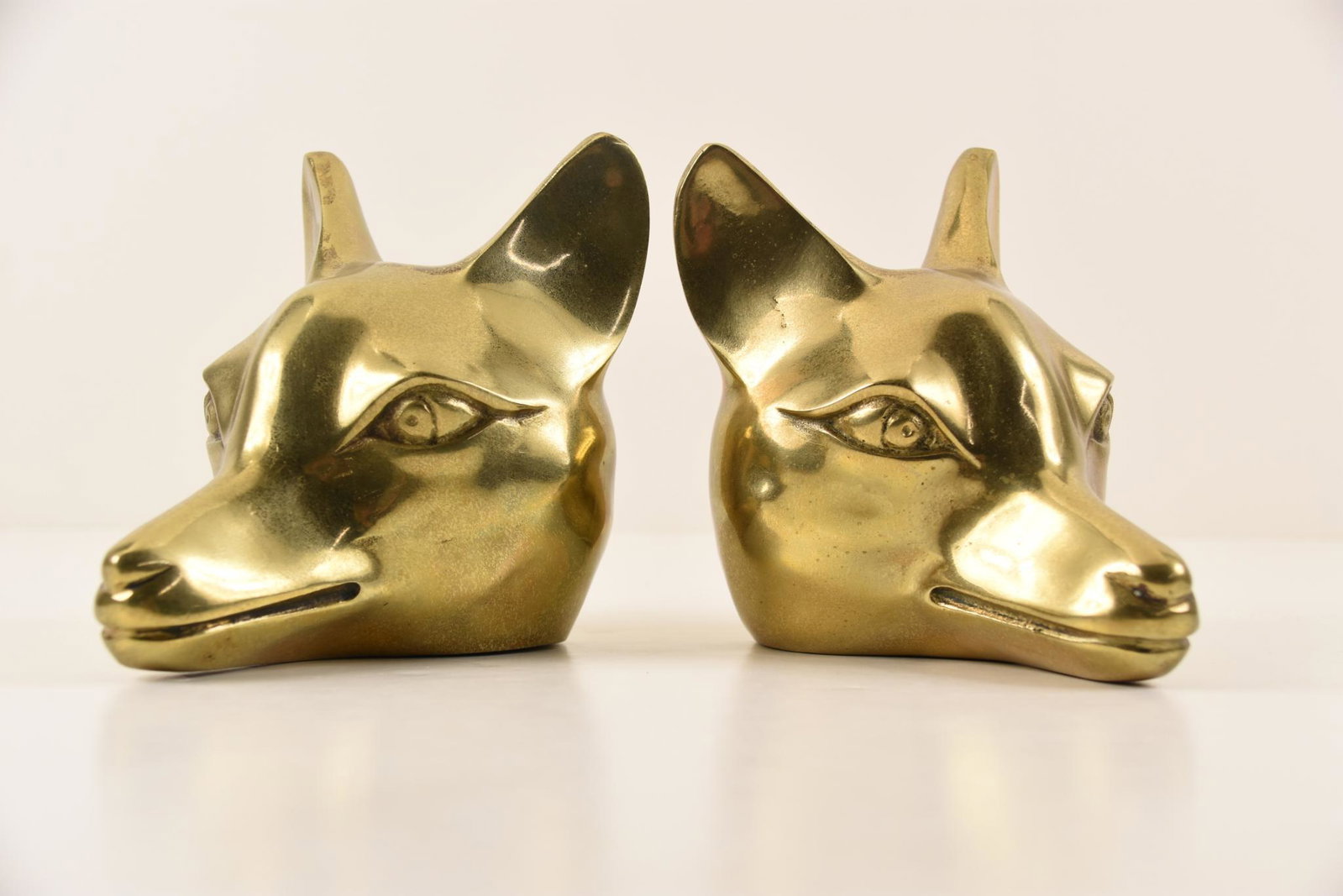 Two (2) Brass Fox Heads: Two (2) solid brass fox head book ends. Made in Korea sticker on the bottom. MEASUREMENTS: 5" x 5" x 3.5" each. CONDITION: Very good.