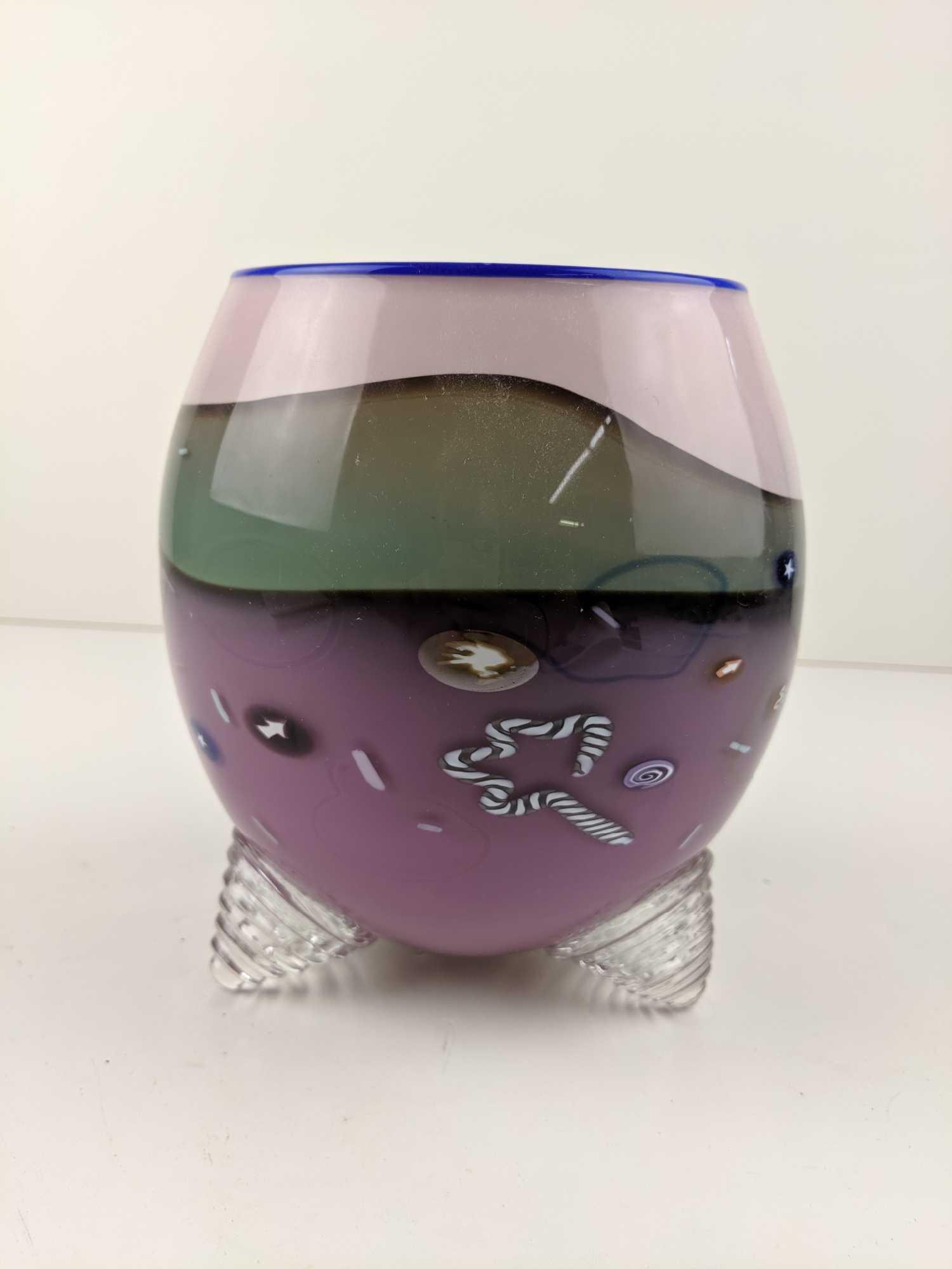 Noble Effort 1980s Art Glass Vase, Signed and Dated: Memphis style 1980s tri-legged art glass vase in blue, purple, pink and teal colors with stars, swirls, and confetti. Signed by Noble Effort, 1987. MEASUREMENTS: 7" x 5" CONDITION: Good. Has a gouge o