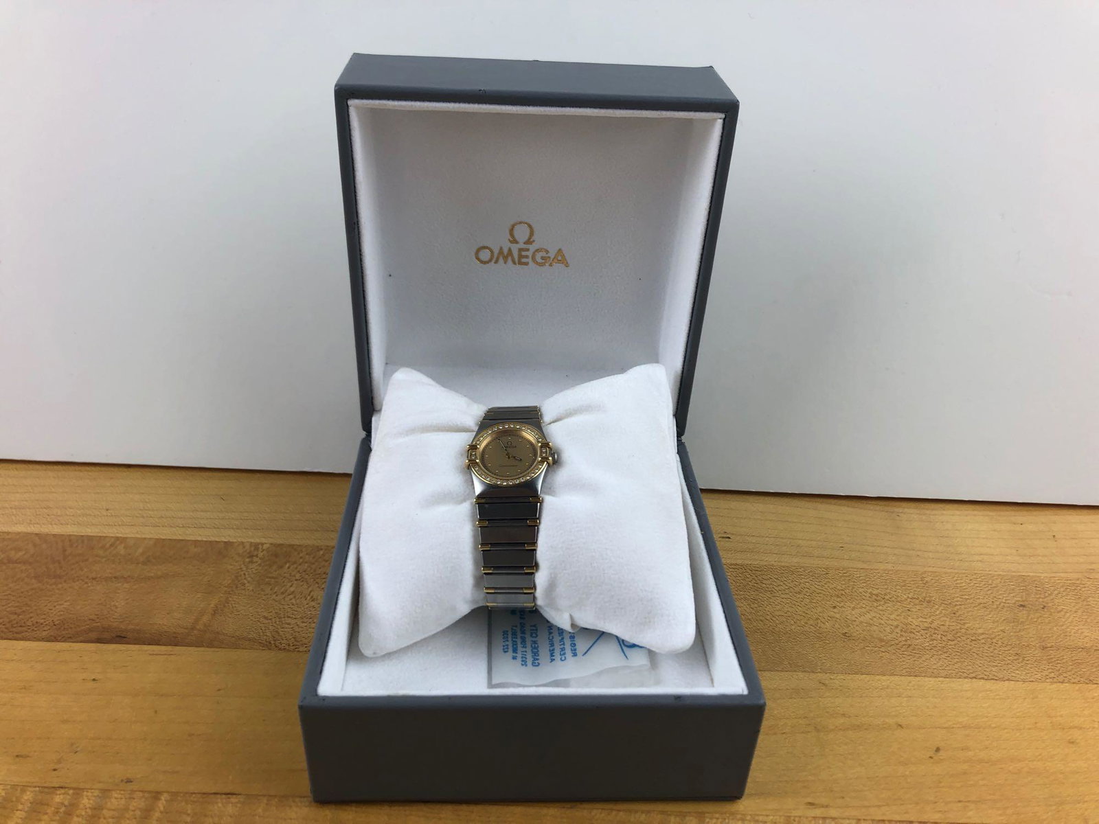 Omega Ladies Constellation Watch: Ladies Omega Constellation watch with gold colored face, and gold and stainless steel band. 32 diamonds, .25CT. With original box and with an Omega Precious Stones Certificate. WEIGHT: 42 g CONDITION:
