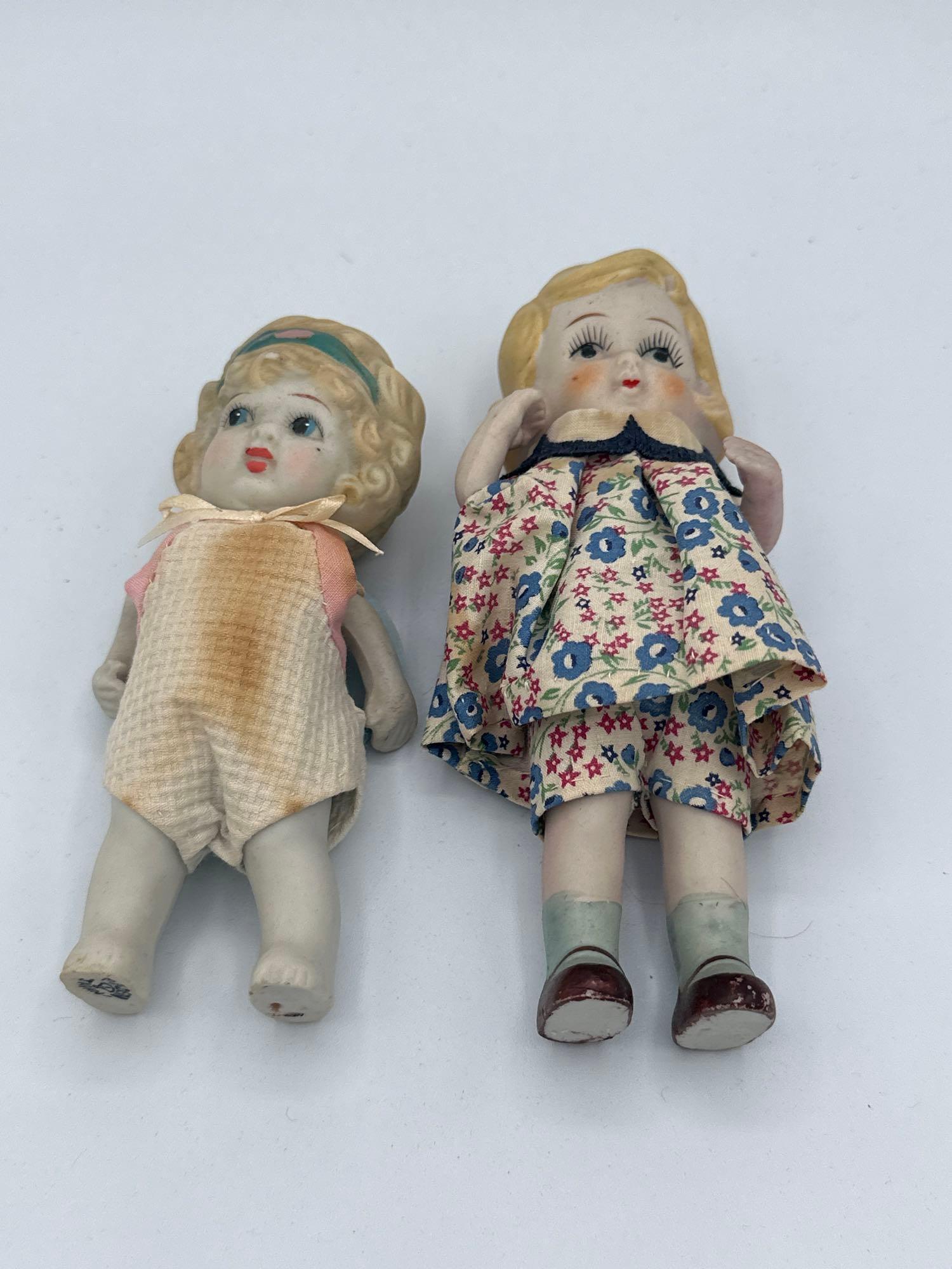 (2) Bisque Girls: (2) Bisque girls: 6 1/2"All bisque girl with floral dress. Made in Japan 1930s 5 3/4" Made in Japan. Hairbrand girl