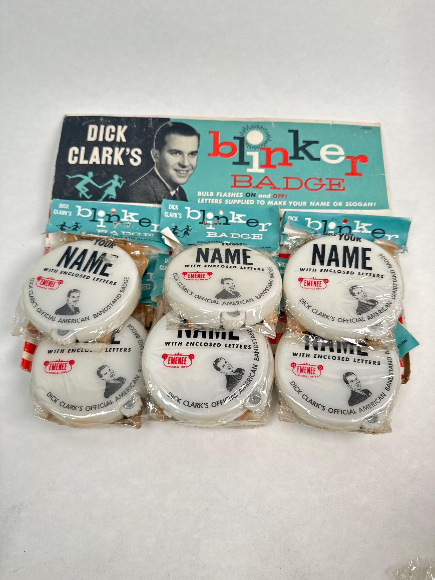 Set of 11 Dick Clark’s blinker badges: Set of 11 Dick Clark’s blinker badges. “Bulb flashes on and off! Letters supplied to make your name or slogan!” advertising by EMENEE musical toys. Dick Clark’s official Americ