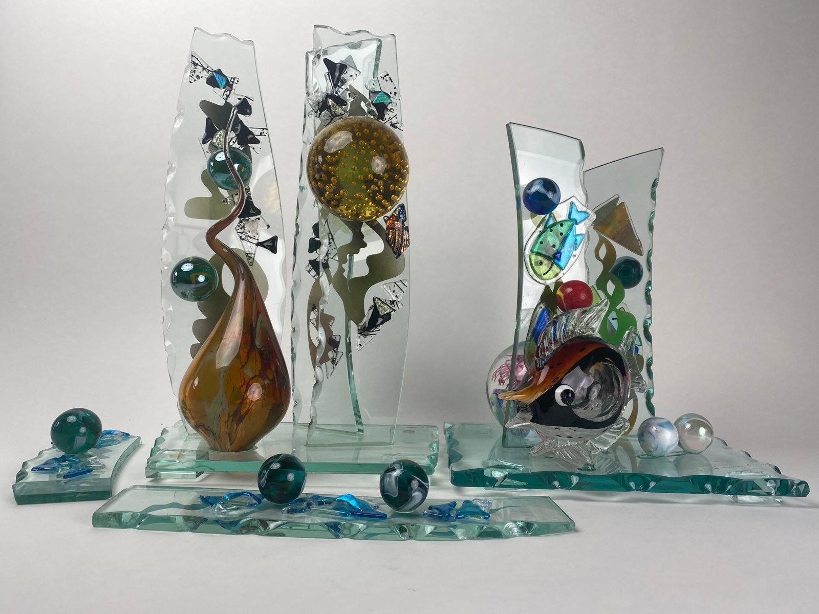 Steve Brewster "Something's Fishy" 3-D Art Sculpture: 3-D sculpture by artist Steve Brewster titled, "Something's Fishy". Produced in 2007, this hand-made piece contains multi-colored glass fused to several vertical pillars on a jagged cut gl