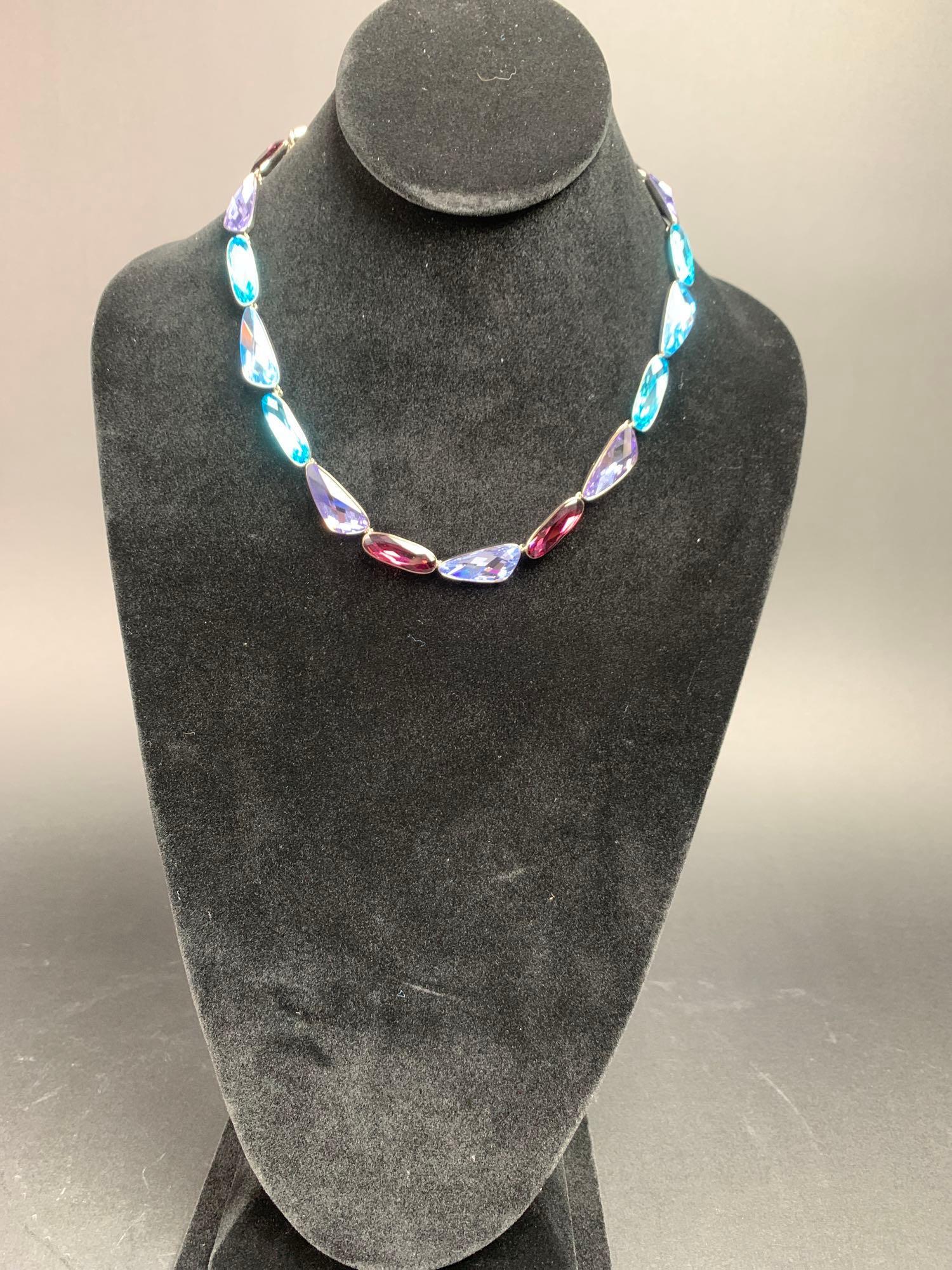 Ombre Swarovski Crystal Necklace: Ombre Swarovski crystal necklace with tags and in the original box. Rhodium plated with a lobster clasp, the crystals vary in tone from turquoise, aquamarine, lavender, and aubergine. Necklace is 18&#