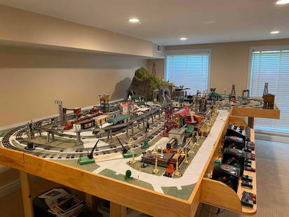 LIONEL TRAINS CUSTOM LAYOUT (14.25' X 9.25' X 7'): Lionel train layout that has been custom made to feature over 75+ Lionel train accessories. This extra large layout comes with three main transformers, multiple vintage accessories and scenic mate