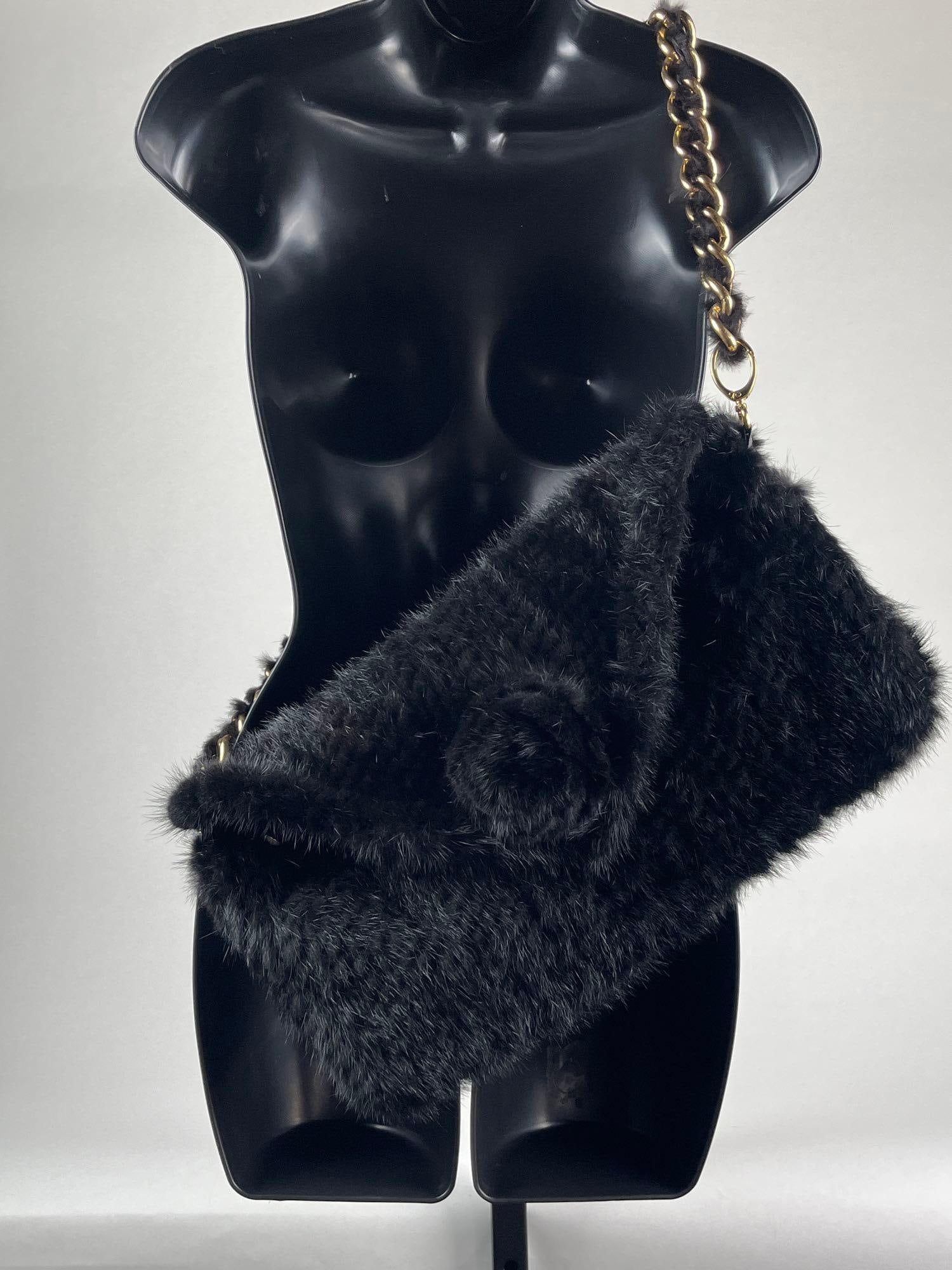 Black Mink Shoulder Bag: Black Mink Shoulder Bag with a gold chain and leather details. Magnetic closure with a 3" (removable) fur rosette pin. The purse is lined in black and in very good condition. Dimensions: 15"l