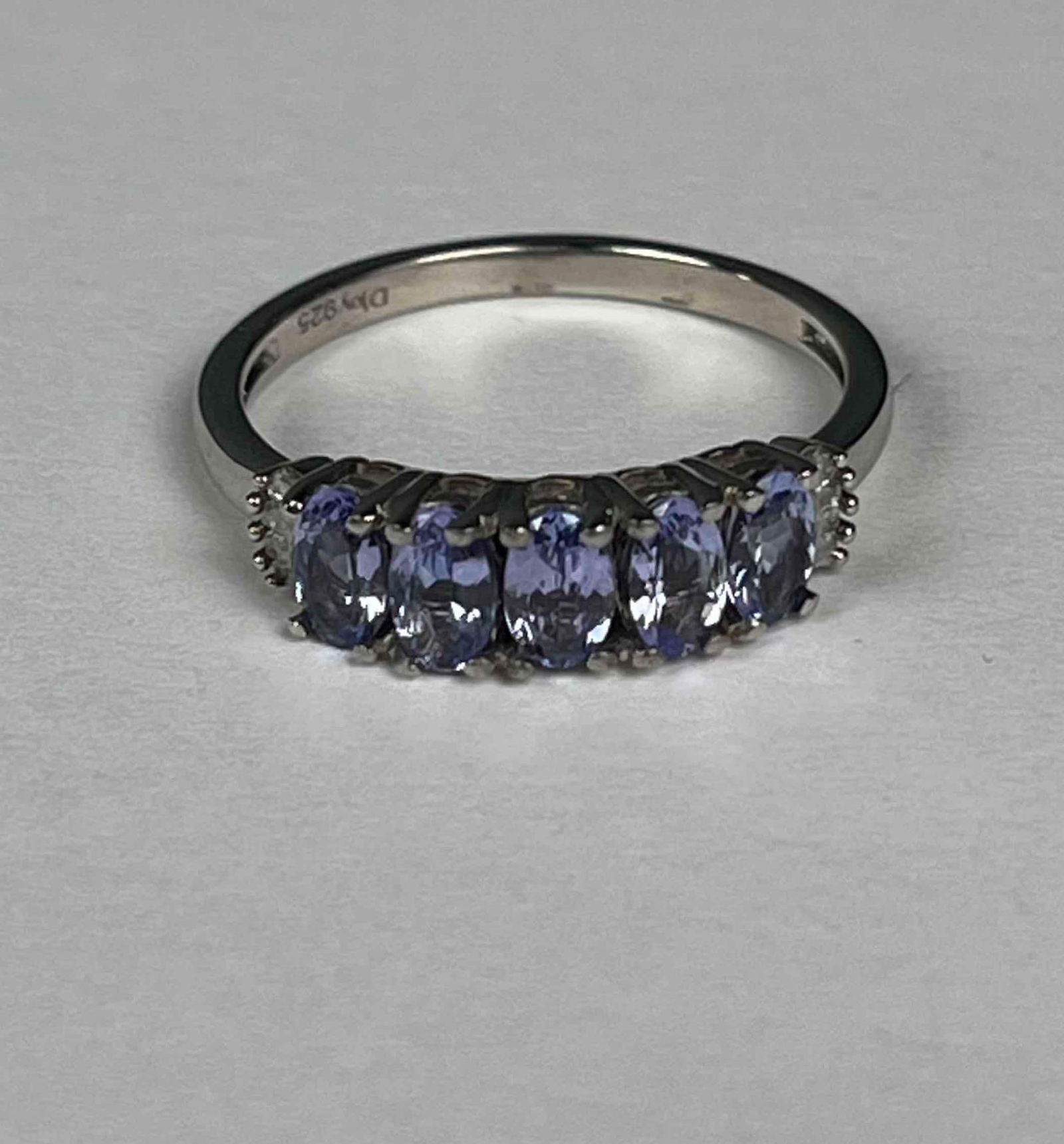Natural Tanzanite 5 Stone and Diamond Ring (Platinum Over Sterling Silver): Sterling silver ring with 5 natural tanzanite oval cut stones and baguette cut diamonds. "925" marking is visible on back of ring. Weighs 1.20 CTW. Size 8. In excellent condition. Please refer to phot