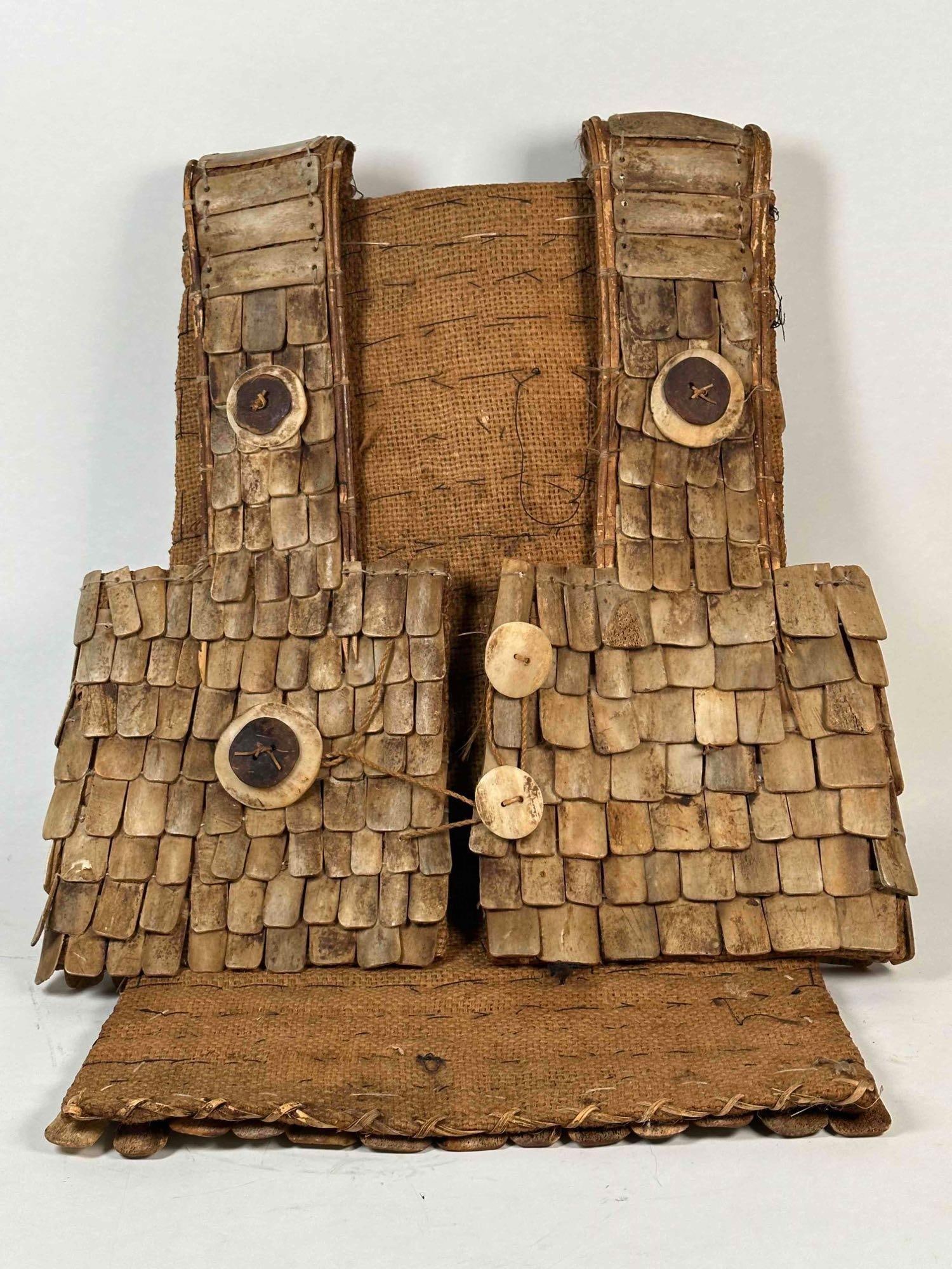 Sulawesi Bone Armor with Stand (19th C.): Torojan War Shirt of finely braided straw construction with multiple individual bone sections to front. Buffalo bone shingles and horn buttons are intact and in good condition. Includes a stand. Dimen