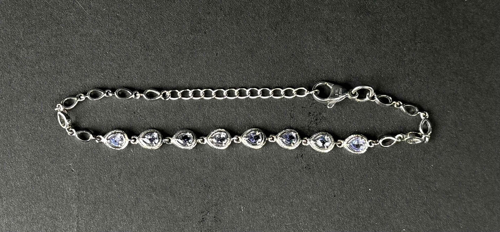 Natural Tanzanite Bracelet: Bracelet with pear cut tanzanite stones. Hardware of bracelet is made of 316L stainless steel. In excellent condition. Please see photos for additional details. | Please note all lots show signs of we