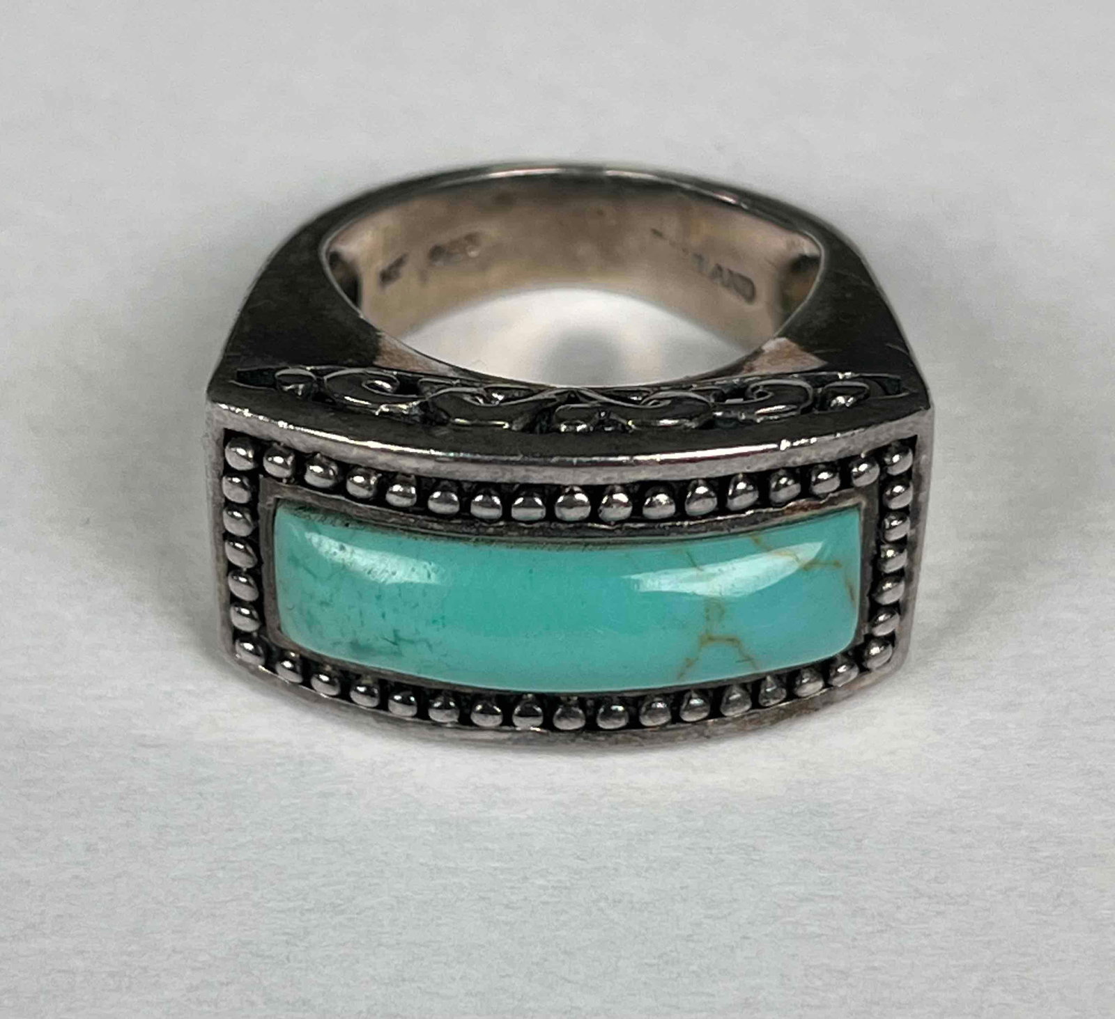 Sterling Silver and Turquoise Ring (Native American): Sterling silver ring with turquoise stone. "925" is visible on back of ring. Made in Thailand. Ring weighs 10 g. In good condition. Please see photos for additional details. Dimensions: Size 5