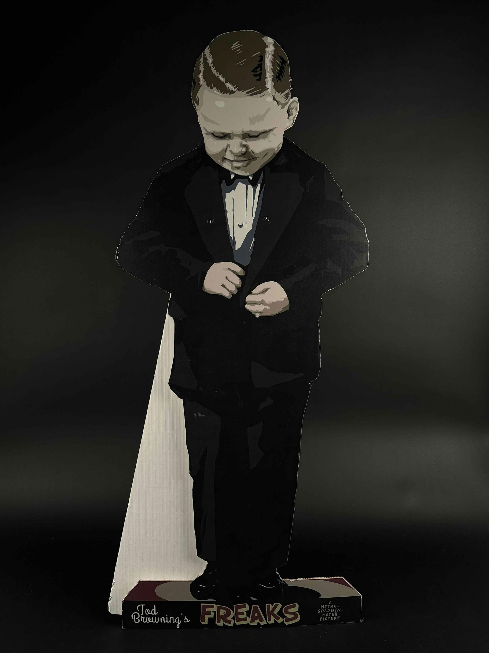 Tod Browning's "Freaks" Hans Cardboard Cutout: Cardboard cutout of Hans from Tod Browning's "Freaks". 2/5 and signature on back reads "Guelker". In excellent condition. Please see photos for additional details. Dimensions: 41