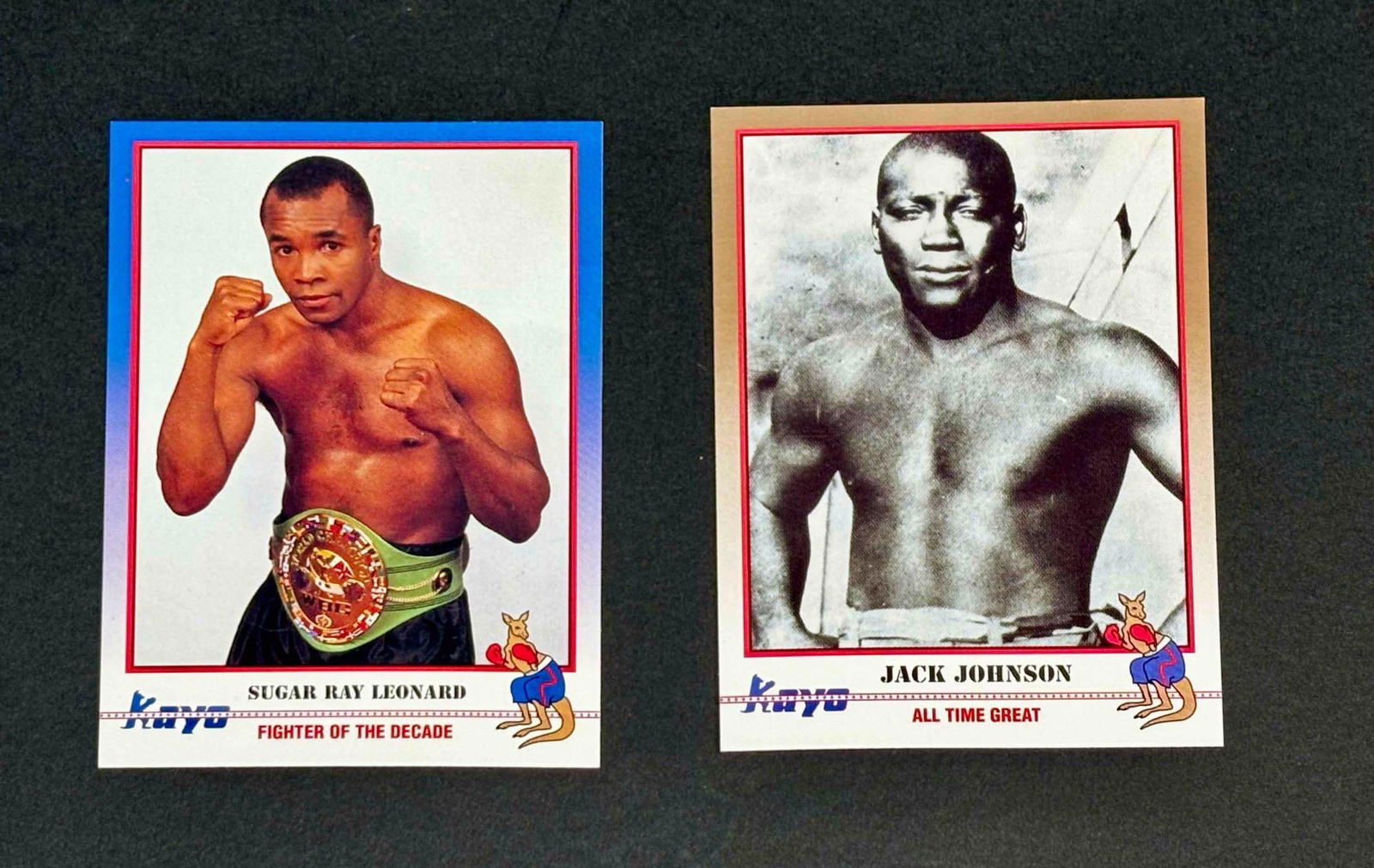 Pair of 1991 Kayo Boxing Cards (Sugar Ray Leonard and Jack Johnson): 191 Kayo Boxing cards #156 (Sugar Ray Leonard) and #064 (Jack Johnson). Please see photographs for additional details. Please note all lots show signs of wear commensurate with age and use, and the la