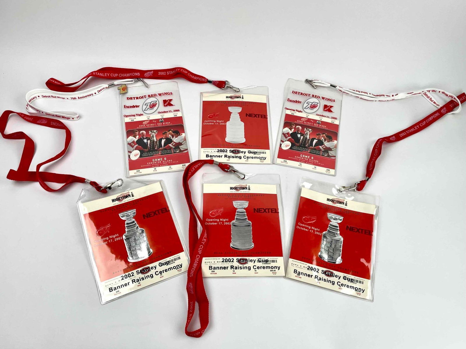 Detroit Red Wings Ticket Holder Lanyard with Tickets: Six ticket lanyards including 4 2002 Stanley Cup lanyards with Opening Night passes, and 2 2000 Opening Night lanyards with passes from Red Wings vs Oilers game. Also includes one Detroit Red Wings pi