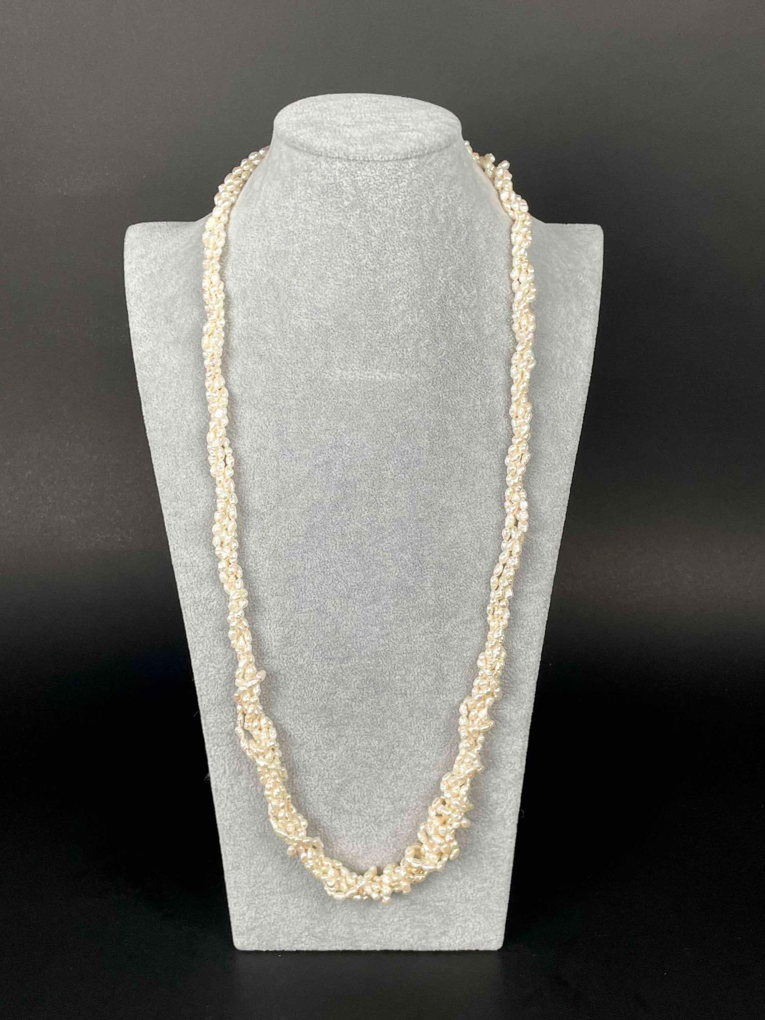 Twisted Freshwater Pearl Necklace: Baroque freshwater pearl strands twisted to form a necklace. Excellent condition. Please see photos for additional details. Dimensions: 32" Weight: 99.17 g Please note all lots show signs of wear comm