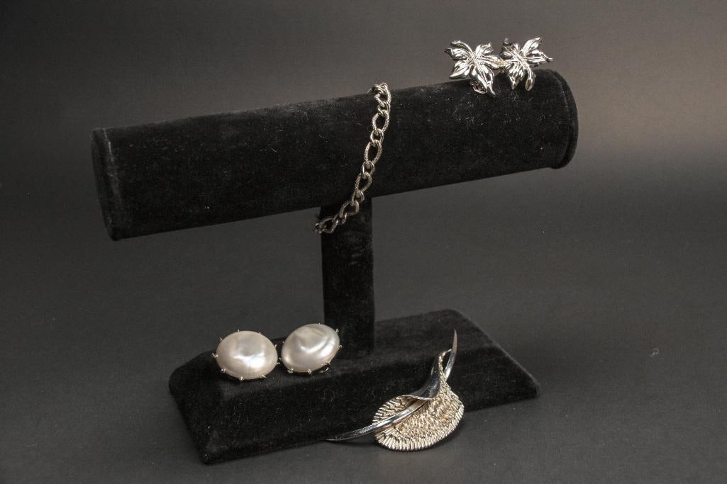 Trifari Costume Jewelry Lot: Trifari costume jewelry lot. Clip on earrings, a silver tone cala lily brooch and silver tone bracelet. Excellent condition. Trifari logos present on earrings and brooch. Please see photos for additio