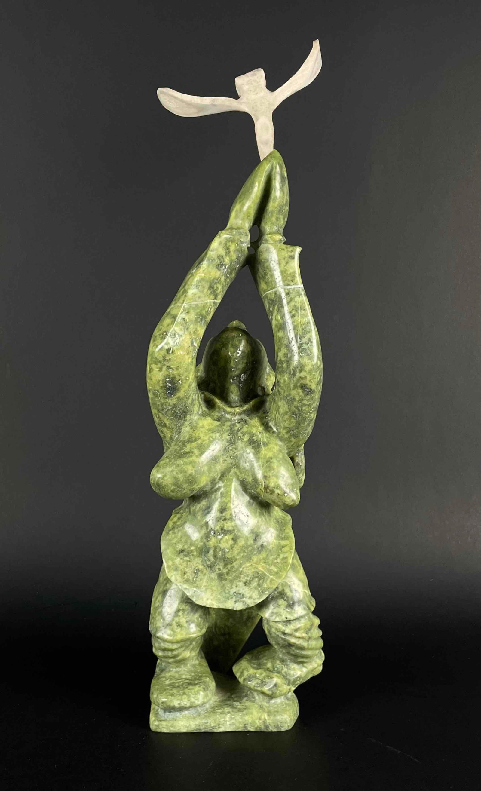Inuit Figural Carving (Kinngait/Cape Dorset): Inuit serpentine sculpture depicting a women offering a wish bone. Polished green stone. Piece is signed in Inuktituk syllabic on the foot. This piece was purchased directly from the artist in Cape Do