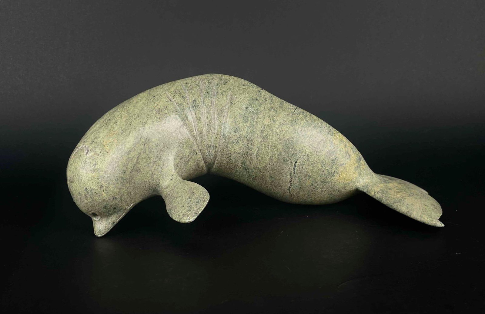 Inuit Narwhale Carving (Kelly Etidloie, 1996): Inuit Narwhal carving missing its horn. Piece is signed by Kelly Etidloie and dated 1996. This piece was purchased by the collector (Jon Jacobs) in Cape Dorset/Kinngait. Piece is in good condition wit