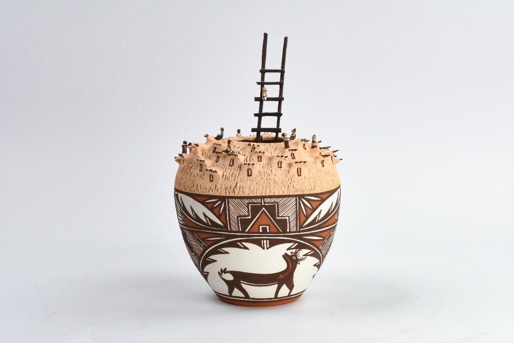 Noreen Simplicio (Zuni, 20th Century) Zuni Polychrome: Signed Noreen Simplicio, Zuni. 11/03. Represents the Zuni Pueblo, surrounding the village kiva with the ladder protruding from the sipapu. Pueblo life is depicted by var. min. characters. The base is 