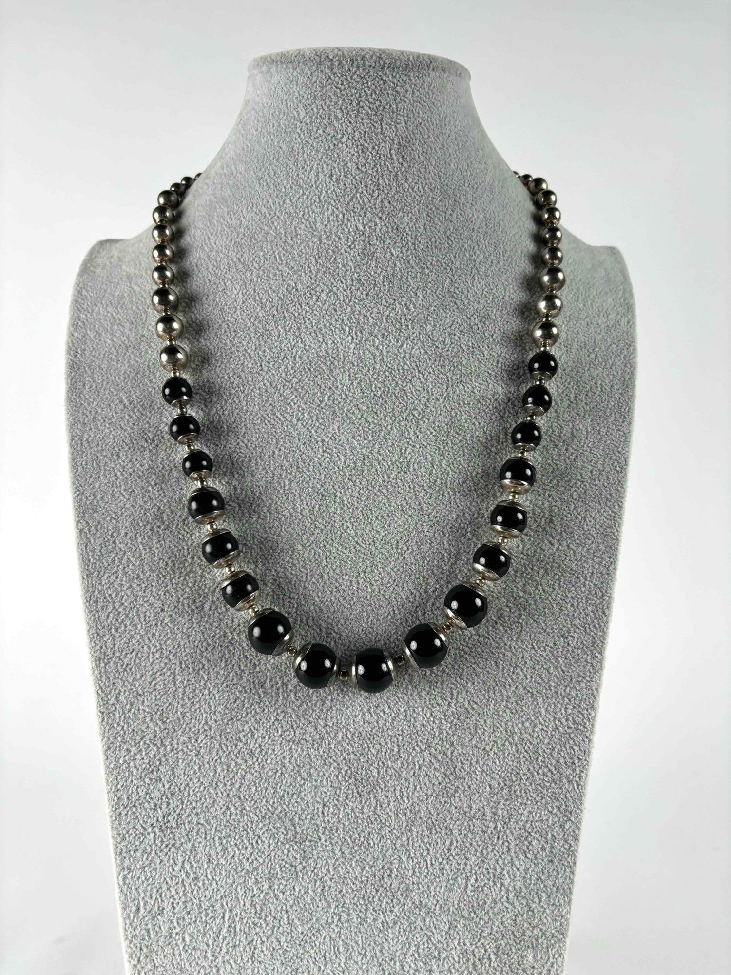 Sterling Silver and Onyx Graduated Beaded Necklace: Sterling silver and onyx graduated bead necklace. Patina is present on silver beads. Signed "LC" as pictured. Please see photos for additional details. Please note all lots show signs of wear 