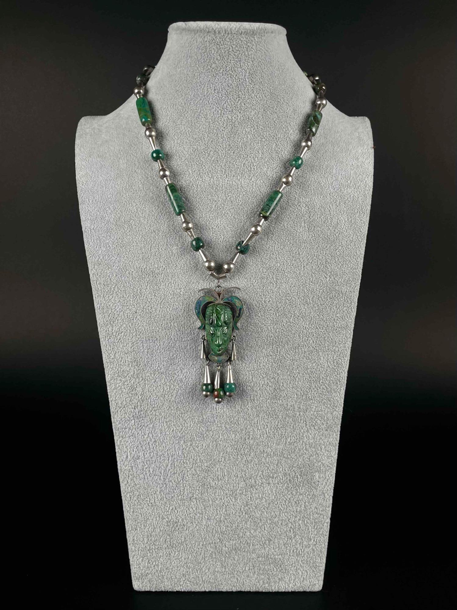 Mexican Taxco Sterling Silver and Malachite Necklace: Mexican Taxco necklace with sterling silver and malachite carved pendent and chain. Pendent shows the face of a Mayan warrior. Sterling silver trademark is located on the back of the pendent. Necklace