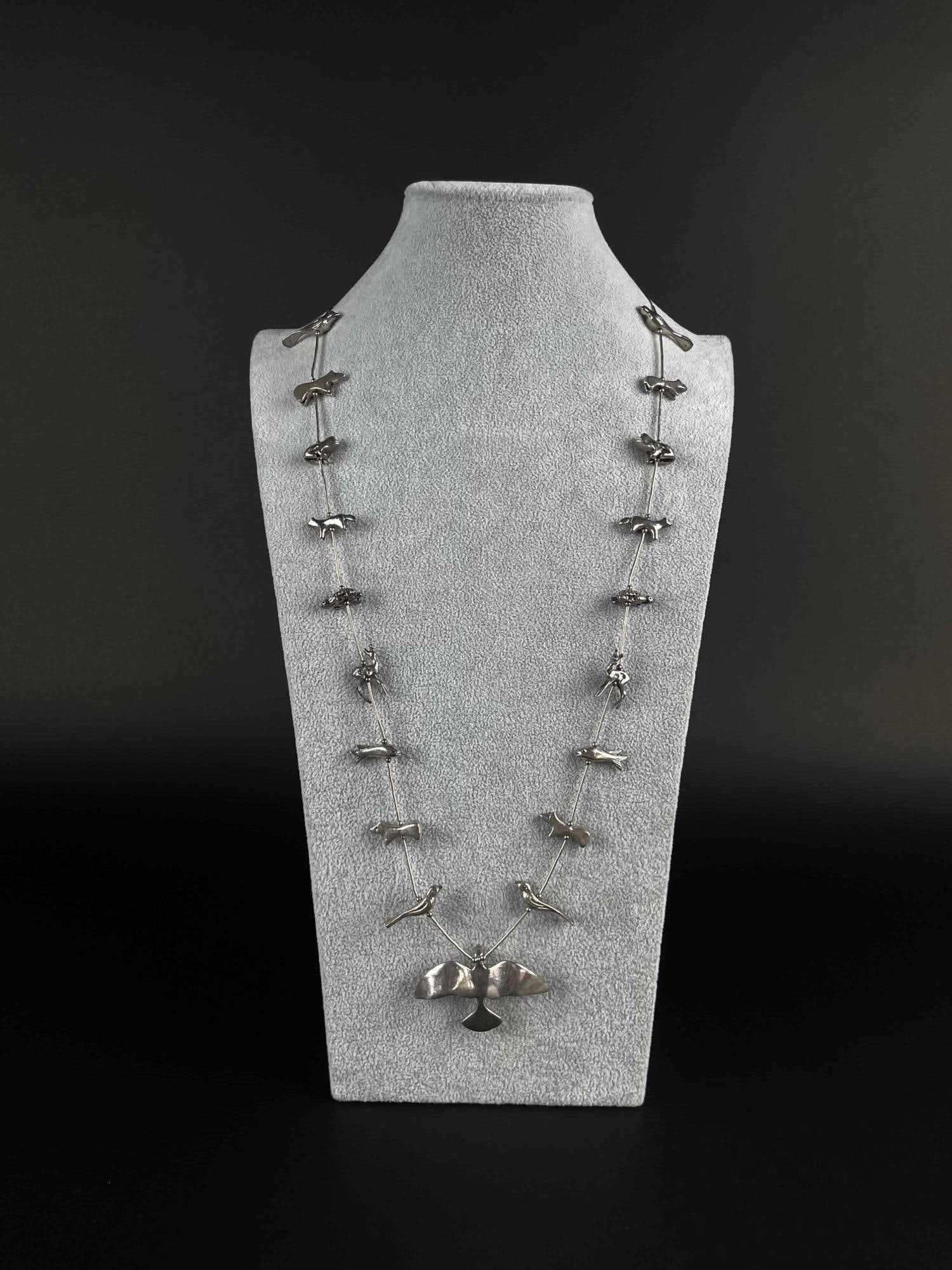 Native American Zuni Fetish Sterling Silver Necklace: Zuni Sterling Silver Animal fetish necklace. Features 19 silver animals such as birds, fish, turtles, and frogs with sterling heshi beads in between. Necklace has a hook and eye clasp. In excellent co