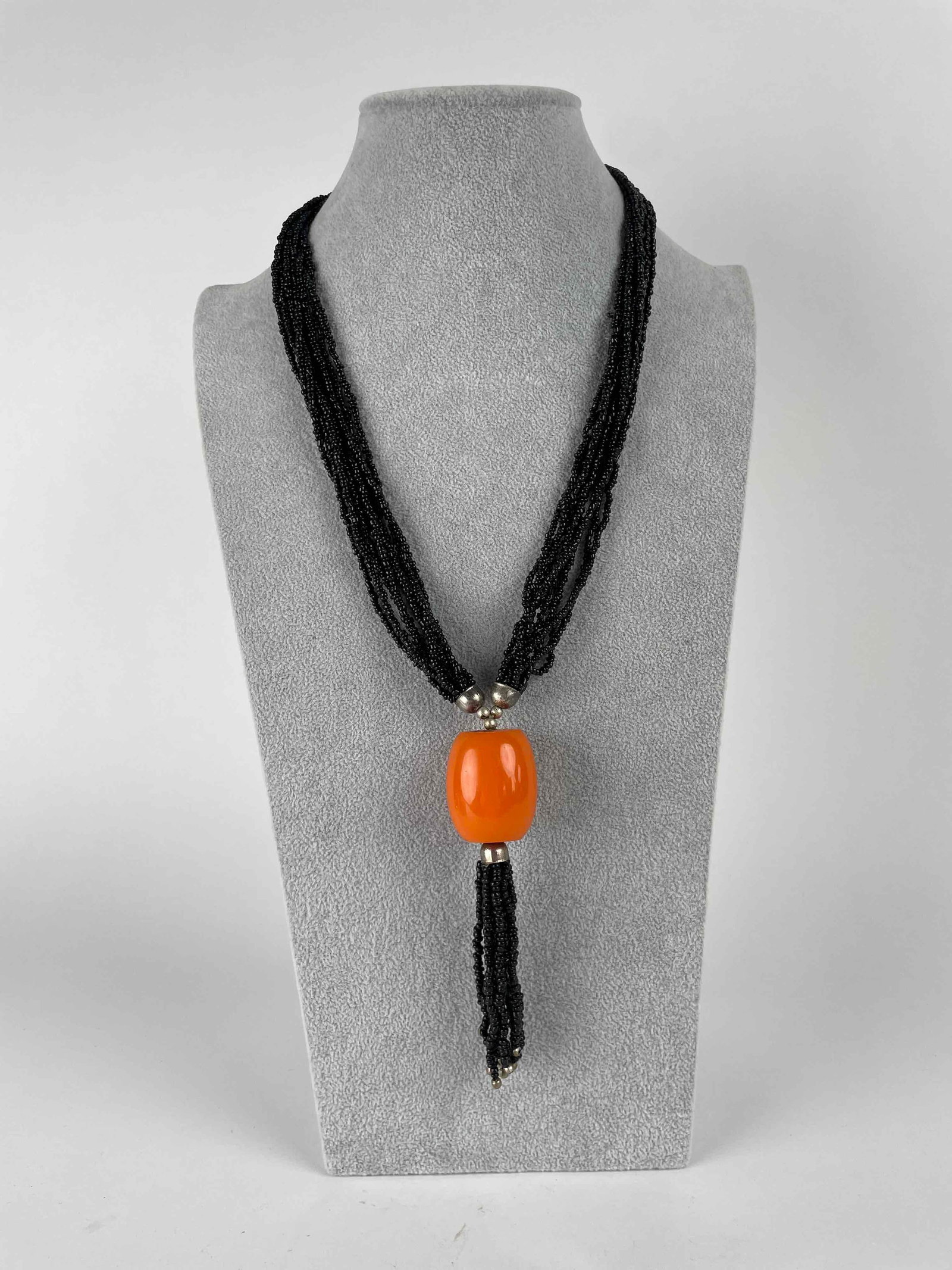 Bakelite and Bead Tassel Necklace: Black and orange beaded necklace with large orange bakelite bead and black tassel. In excellent condition. Please see photos for additional details. Dimensions: 16" long Weight: 84.4 g Please no