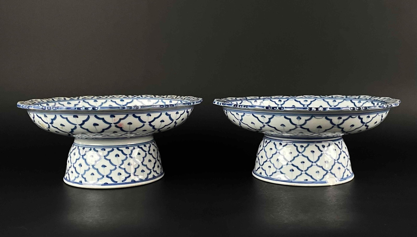 Pair of Southeast Asian Blue and White Porcelain Pedestal Dishes: Pair of Chinese blue and white porcelain centerpiece platters. Traditional blue and white porcelain with stylized floral and geometric shapes. From the home of Jon Jacobs, a prominent collector in Mic