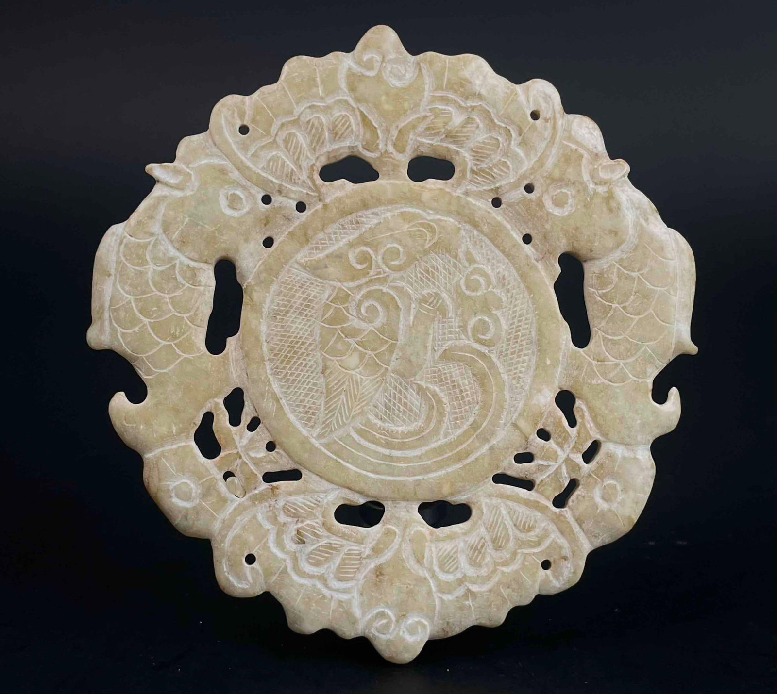 Chinese Carved Natural Jade Bi Medallion: Chinese natural Jade Bi medallion with bird detail carved into center. There are fish and winged figures surrounding circumference of disc. From the home of Jon Jacobs, a prominent collector in Michig