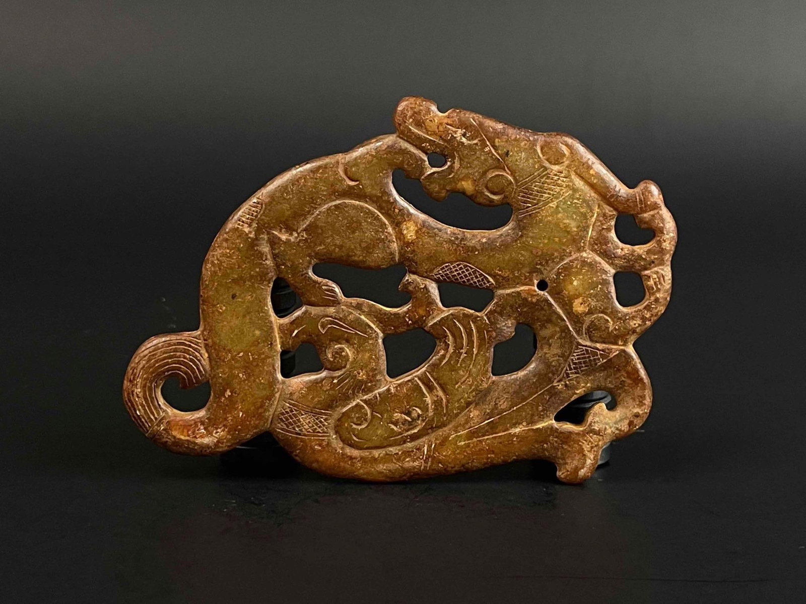 Chinese Carved Natural Jade Pendant: Chinese carved natural jade pendant depicting a dragon figure eating another creature. Additional etched detailing. From the home of Jon Jacobs, a prominent collector in Michigan. Please see photos fo