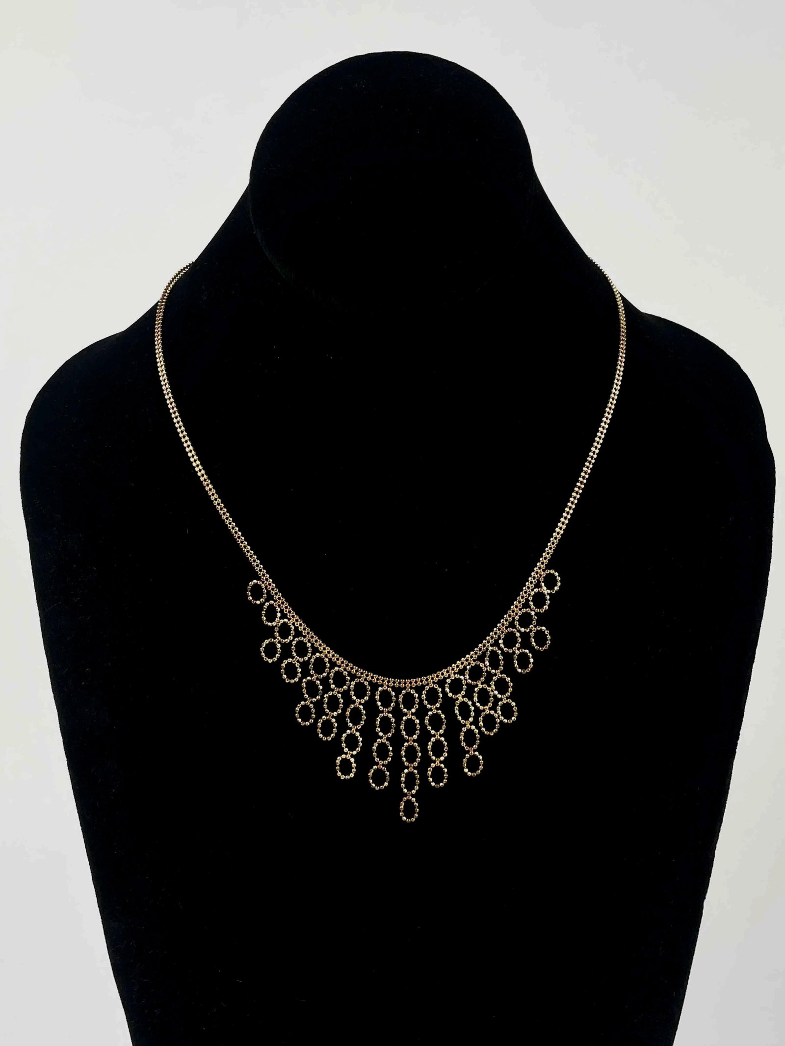 14K Gold Bib Necklace: 14K gold bib necklace. Necklace has a round link chain with circle drop pattern creating a triangular shape at center. 14K gold hallmark is present on the lobster clasp. In excellent condition. Please