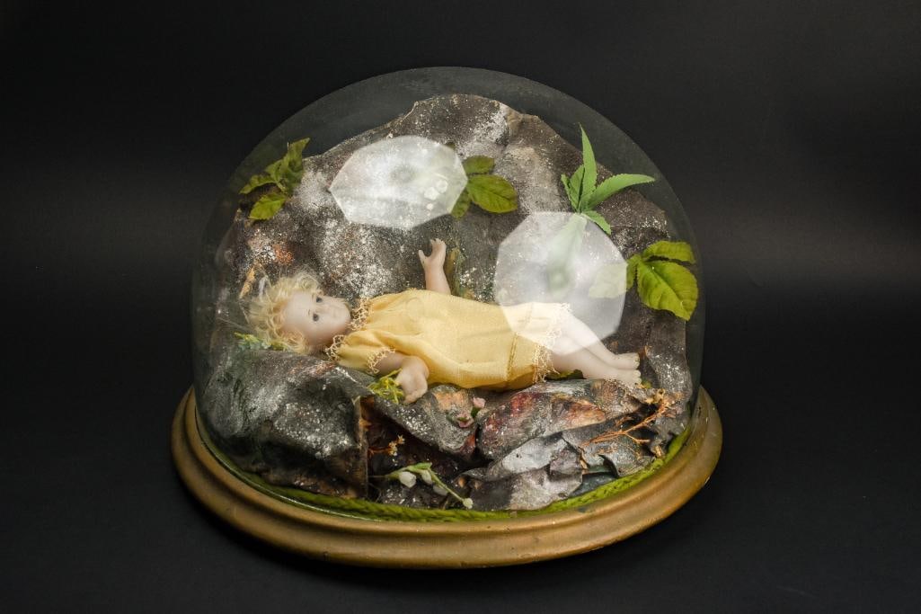 Victorian Wax Effigy Mourning Doll in Glass Dome: Victorian poured wax effigy child doll. Rare. Mourning doll has been kept in a glass dome with rocks and foliage. She is wearing a yellow dress. From the private collection of Jon Jacobs, a prominent 