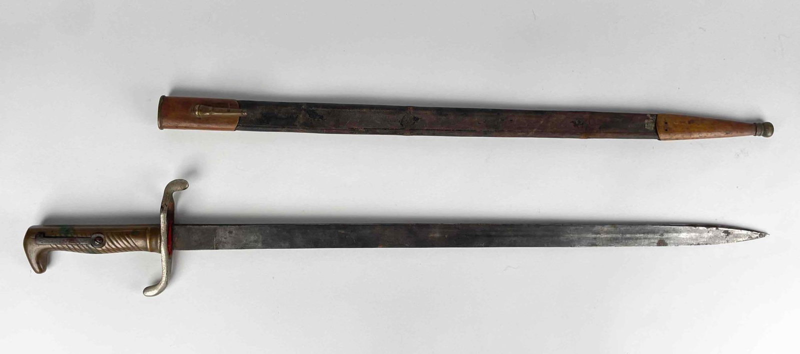 Antique Bayonet with Brass and Leather Scabbard: Antique bayonet sword with brass hilt. Scabbard is leather with brass trim. Sword is in good antique condition with age related wear and substantial oxidation. Please see photos for additional details