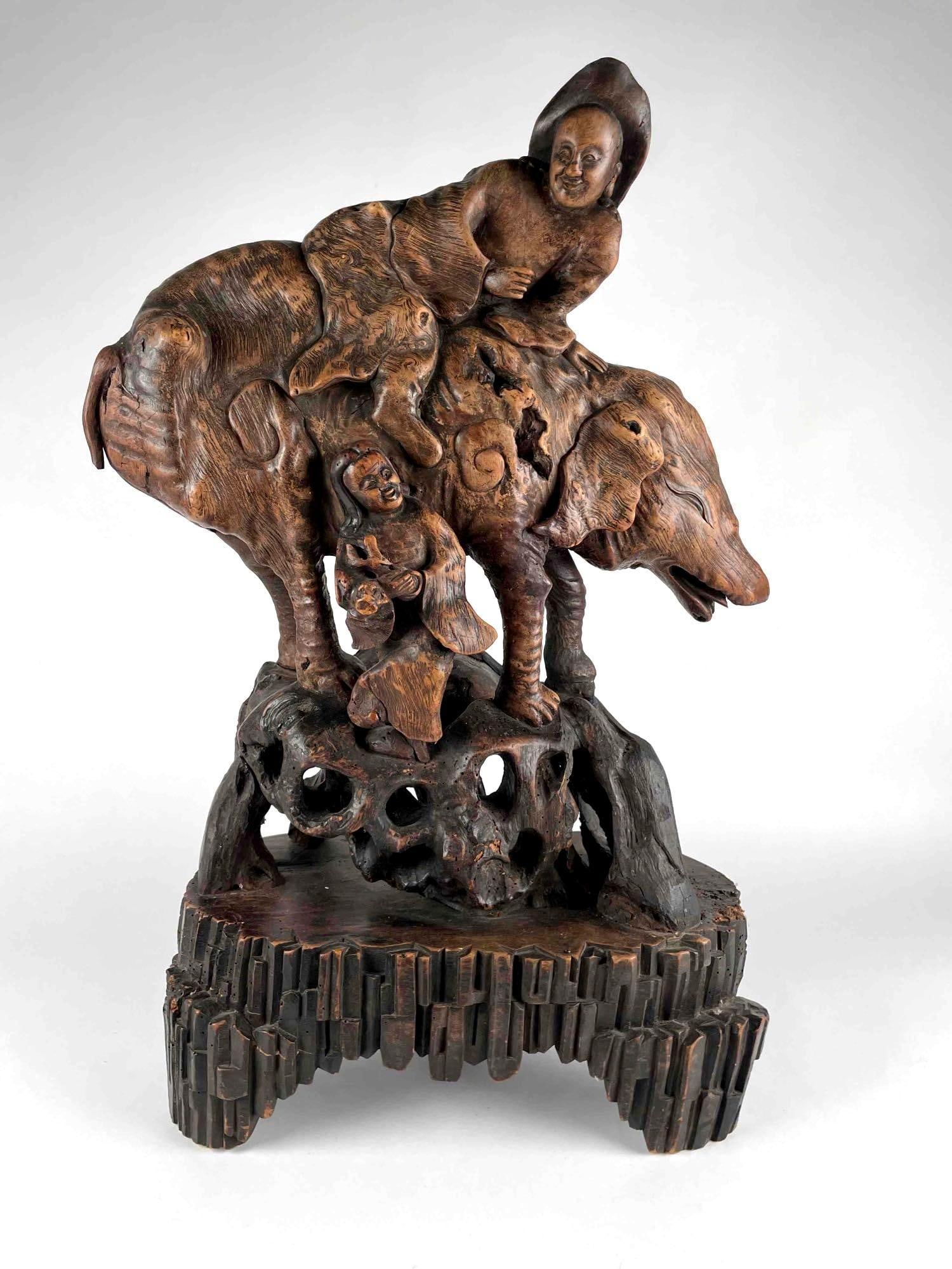 Chinese Wood Carved Sculpture: Chinese wood carving depicting two people and a large pig figure. Figures stand upon a carved wood base. From the home of Jon Jacobs, a prominent collector in Michigan. Sculpture is in good condition 