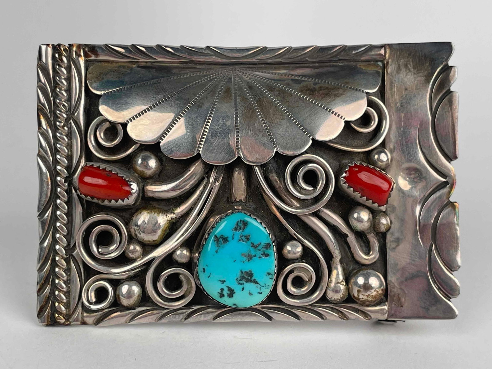 Signed Sterling Silver with Turquoise and Coral Belt Buckle: Sterling silver belt buckle with one turquoise and two coral stones. Belt buckle has an ornately detailed design. "A. Arthur '81" is incised into back. In excellent condition with light tarnish in are