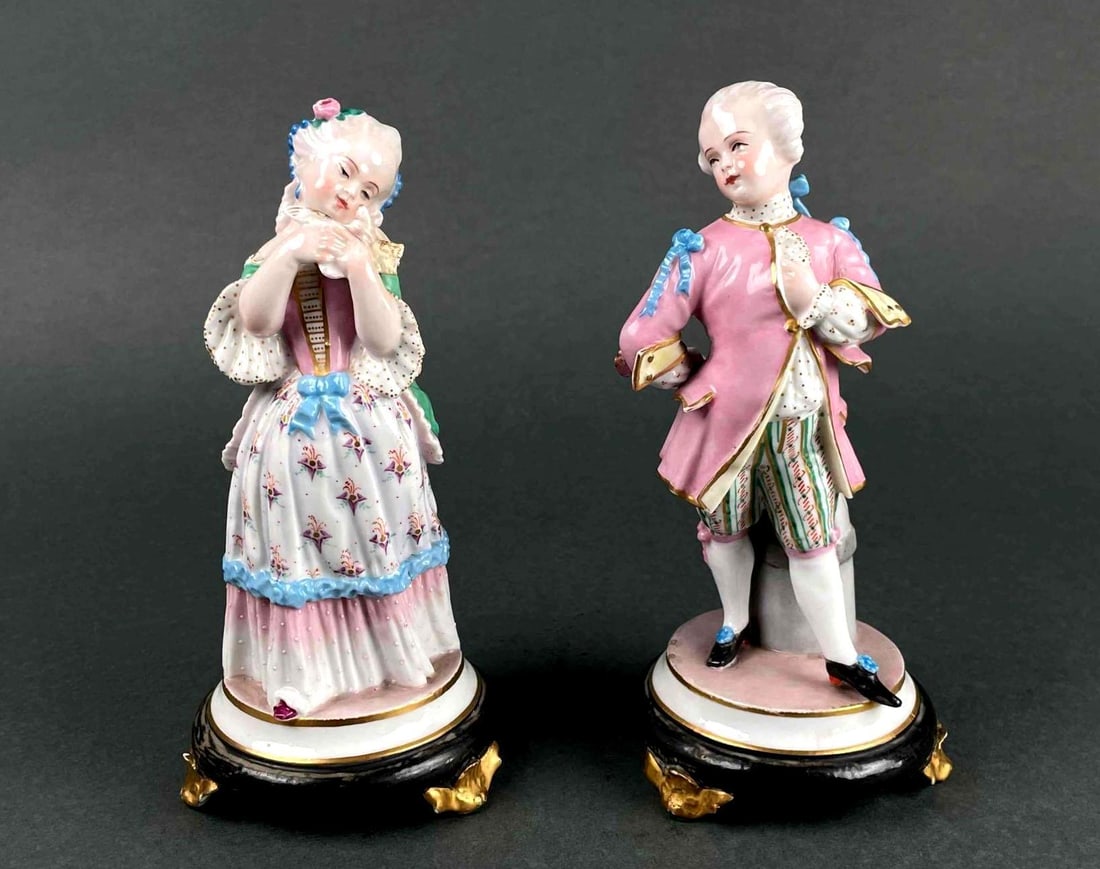 Pair of 19th Century French Figurines: Pair of 19th Century Jean Gille figurines of a male and female. Female holds a bird. Both figurines are hand painted with colors of pink, blue, greens, and gilted details. Male figurine is in excellen