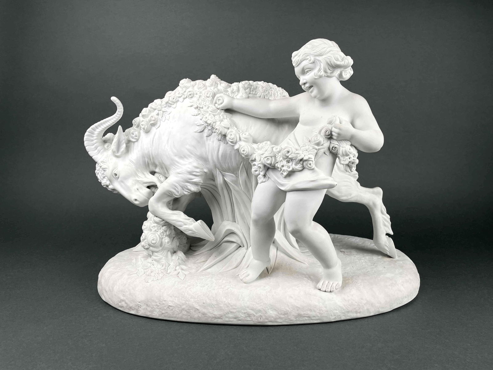 Armand Godard "Child Playing with Goat" Bisque Sculpture: Armand Godard "Child Playing with Goat" bisque sculpture. Child and goat are draped with a vine of flowers. Artist signature is present on base. Numbers "7501" is incised underneath base. In good cond