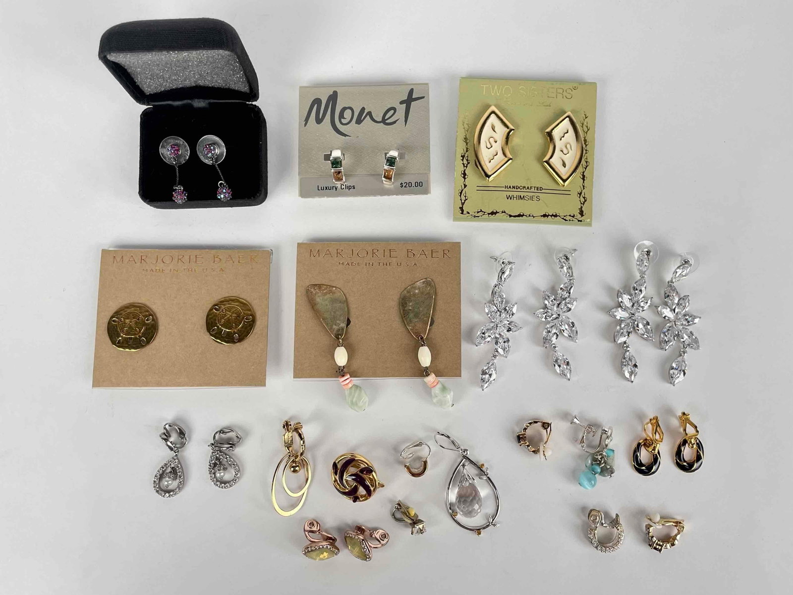 Assorted Costume Jewelry Earrings: Assorted jewelry in various designs by various makers including Monet, Marjorie Baer, Two Sisters, etc. Please see photos for additional details. Total Weight: 148.16 g Please note all lots show signs