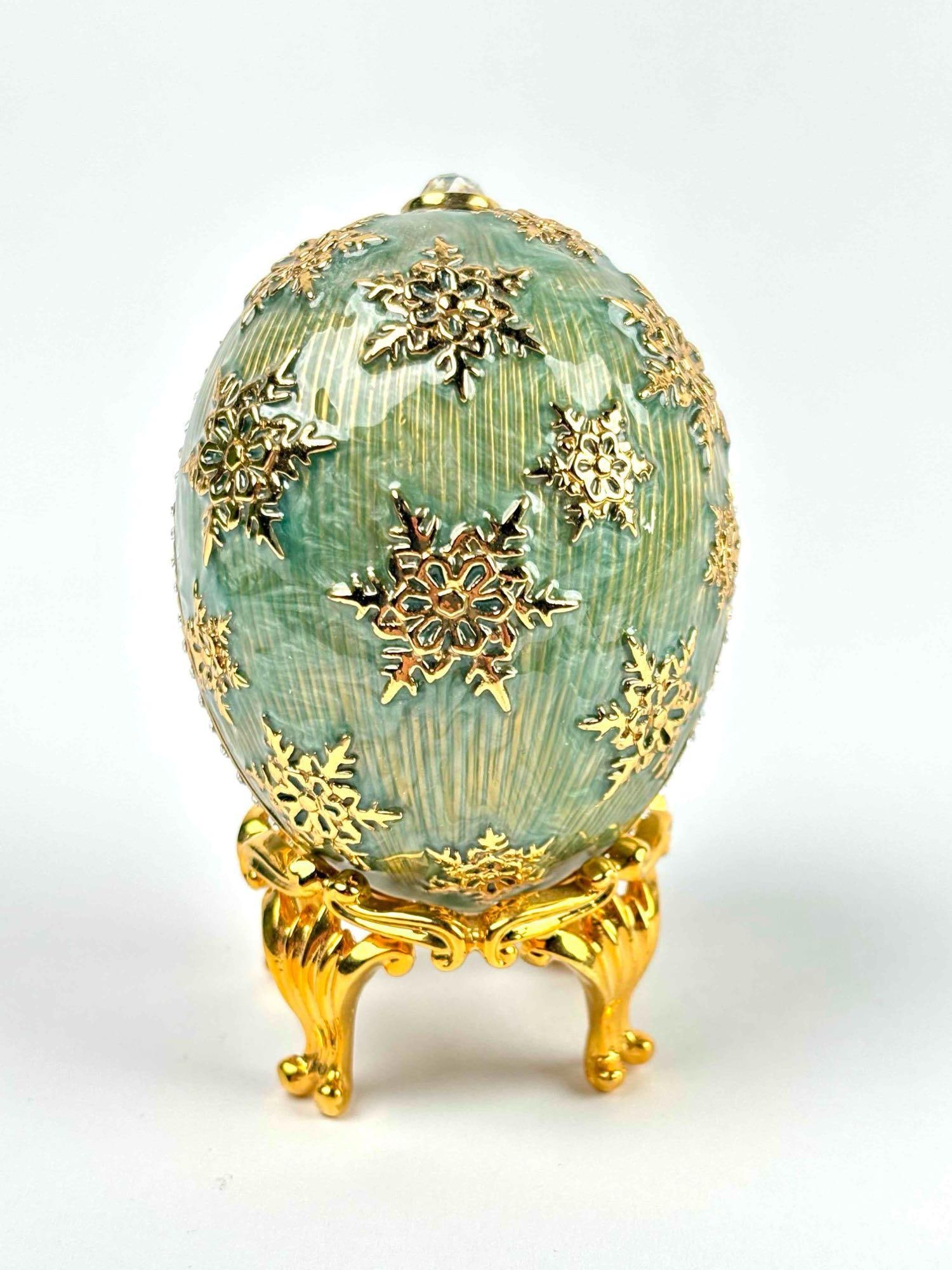 Joan Rivers 2008 Limited Edition Imperial Treasures Egg (COA and Original Box): Imperial Treasures egg box by Joan Rivers. Limited edition, 2008. Green enamel with gold tone snowflake applique and crystal embellishment. Egg comes in its original box with COA. Excellent condition.