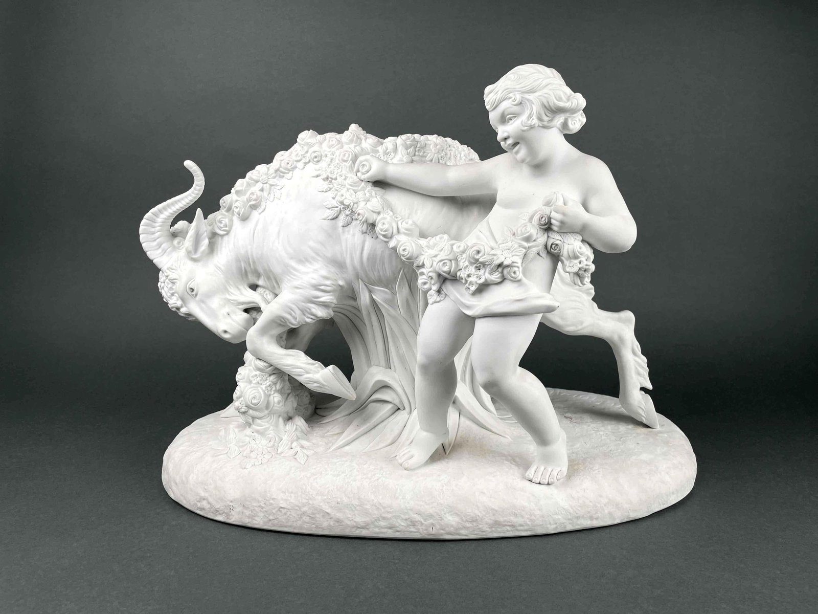 Armand Godard "Child Playing with Goat" Parian Sculpture: Armand Godard "Child Playing with Goat" bisque sculpture. Child and goat are draped with a vine of flowers. Artist signature is present on base. Numbers "7501" is incised underneath base. In good cond