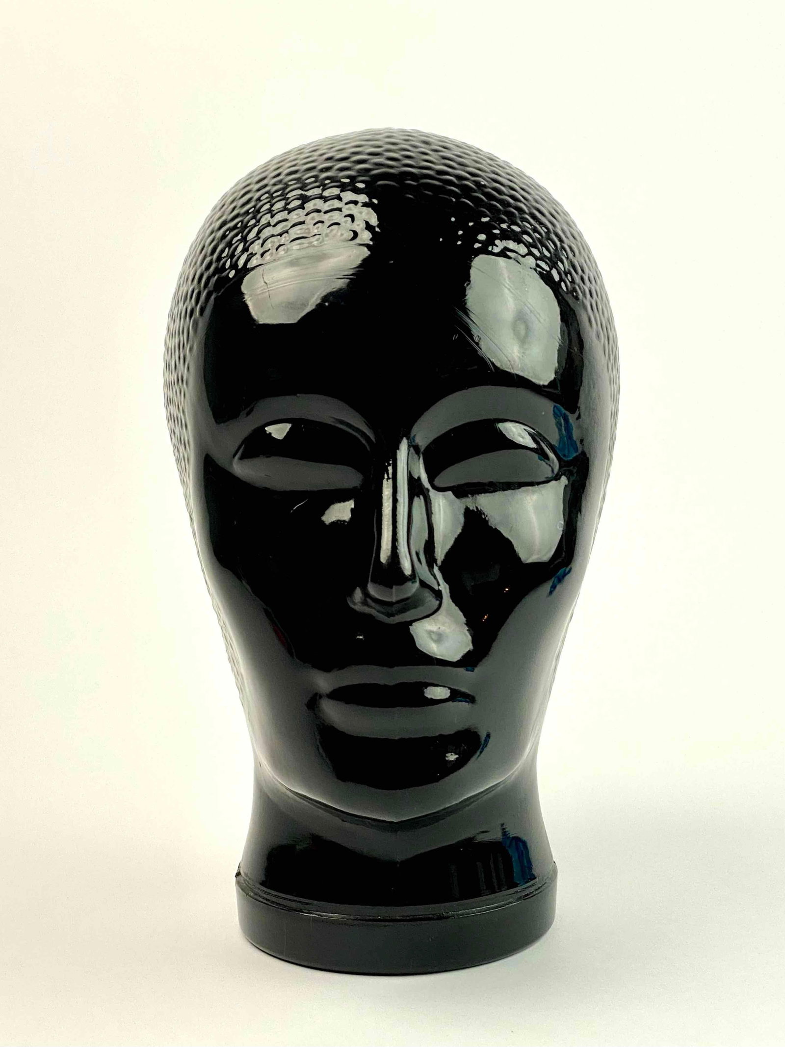 Atelier Fornasetti Glass Head Sculpture: A glass head sculpture by Atelier Fornasetti. Glass head is black in color with smooth facial features and textured hair on skull area. Sculpture is hollow. In good condition with signs of wear that a