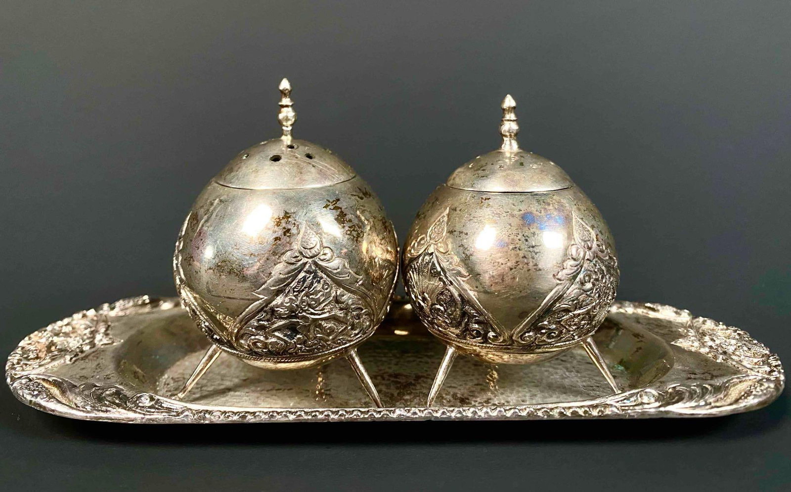 Silver Indonesian Salt and Pepper Shaker Set with Tray (Coin Silver): Silver salt and pepper shaker set with tray made with coin silver. Both sphere like shakers have legs to sit on top of the tray. Tray is stamped 800 MD and made in Jogja. Lot is in good condition. Ple