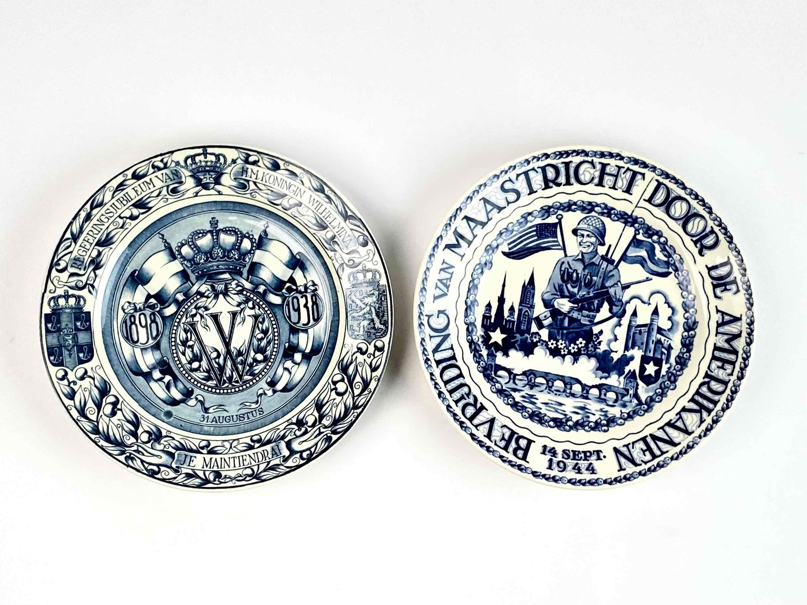 Two Blue and White Porcelain Maastricht Plates: Two blue and white porcelain Maastricht plates. Made in Holland. Includes 1944 Liberation of Maastricht by the Americans plate. Title wraps edge of plate with motif in the middle. Dated September 14,
