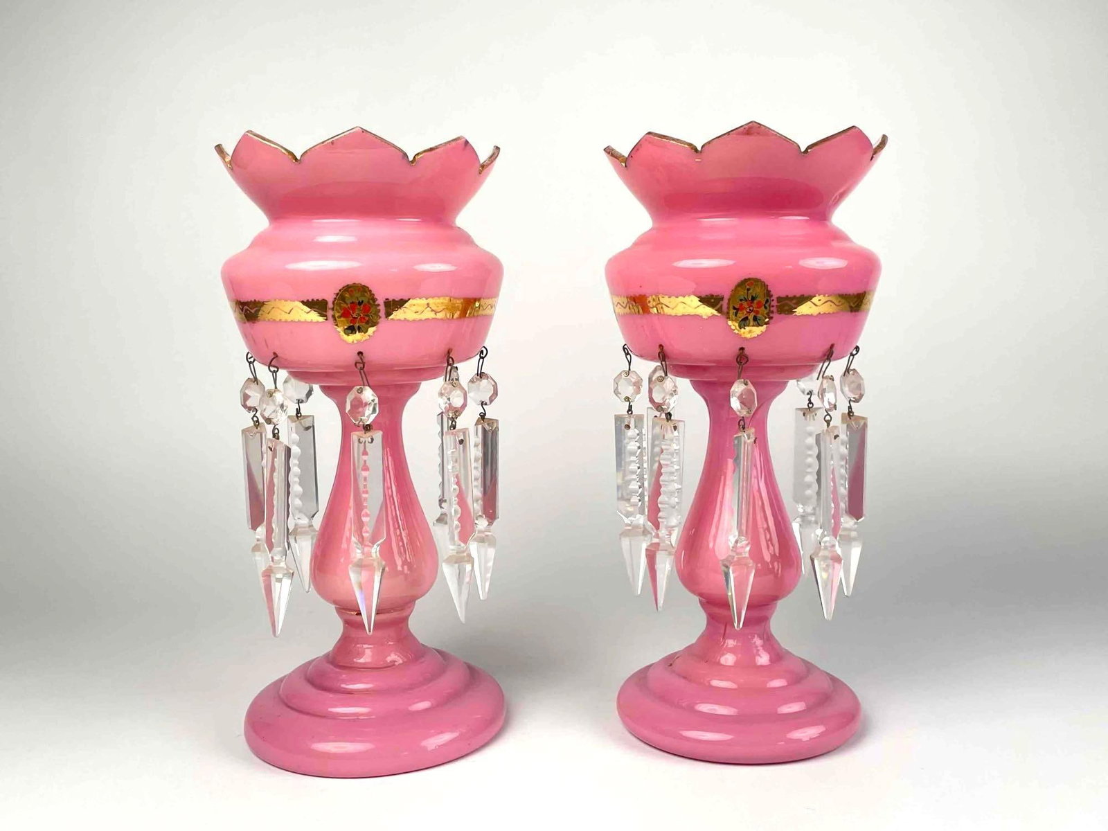 Pair of Pink Victorian Mantle Lusters: Pair of Victorian mantle lusters with dangling crystal prisms. Pink in color with gilt detailing. Mantle lusters are in good condition with signs of wear that are consistent with age and use. Signs of