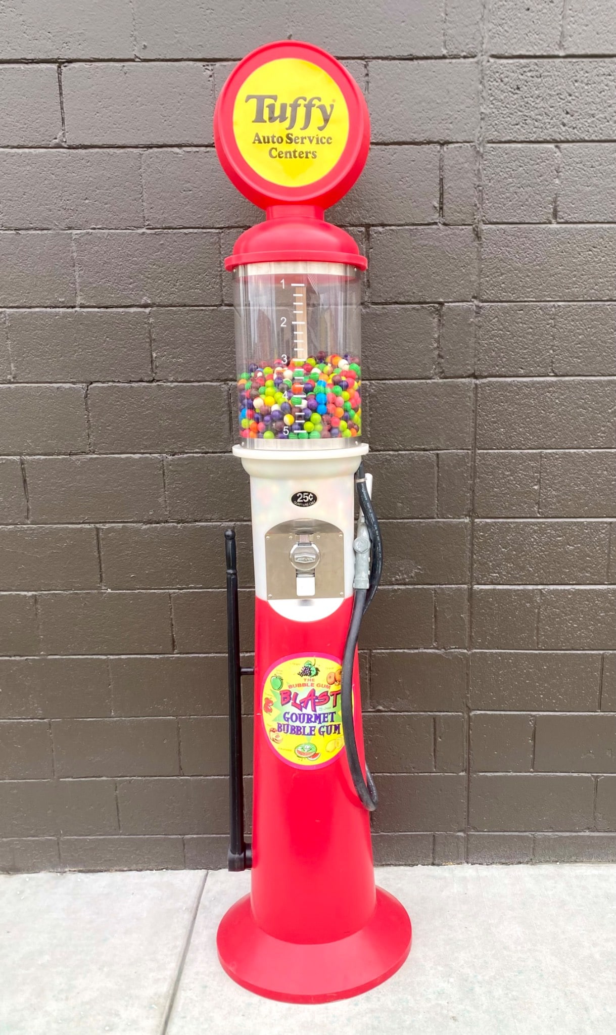 Tuffy Auto Service Centers Themed Bubble Gum Machine: A 25-cent bubble gum machine featuring Tuffy Auto Service Centers branding. Constructed in a vibrant red and white color scheme, it includes a Beaver coin mechanism and a transparent gum reservoir fil