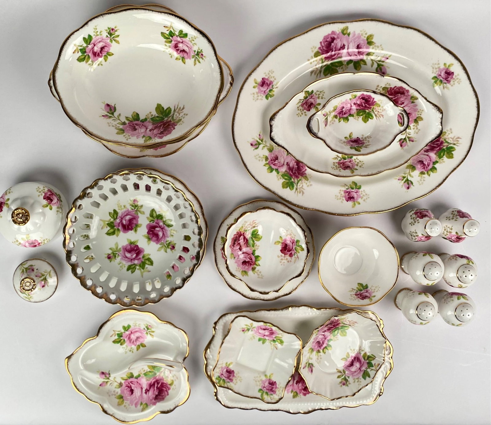 26 Piece Assortment of Royal Albert American Beauty Bone ChinaÂ : 26 piece assortment of Royal Albert American Beauty china set featuring an array of pieces adorned with pink rose floral designs and gold trim. Includes plates, bowls, serving dishes, salt and pepper