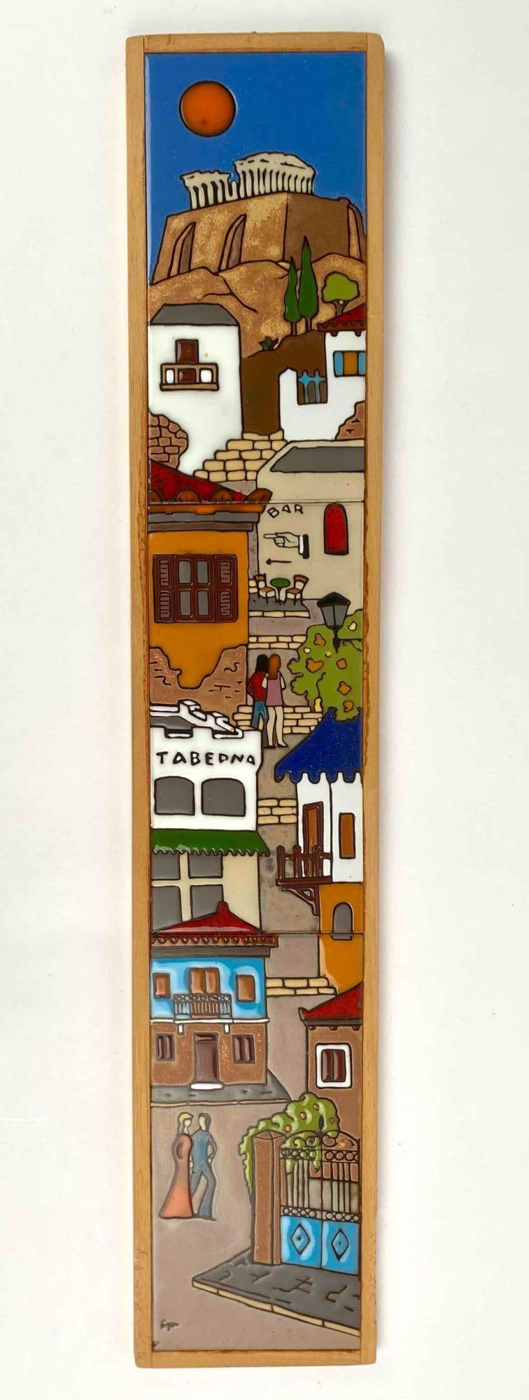 Hand-Painted Greece Tile Artwork in Wooden Frame by Angelo Tsakirakis: Hand-painted Greece tile artwork depicting a vibrant Mediterranean scene with the Parthenon, village houses, and a taverna by Angelo Tsakirakis. Encased in a wooden frame with hanging hardware affixed
