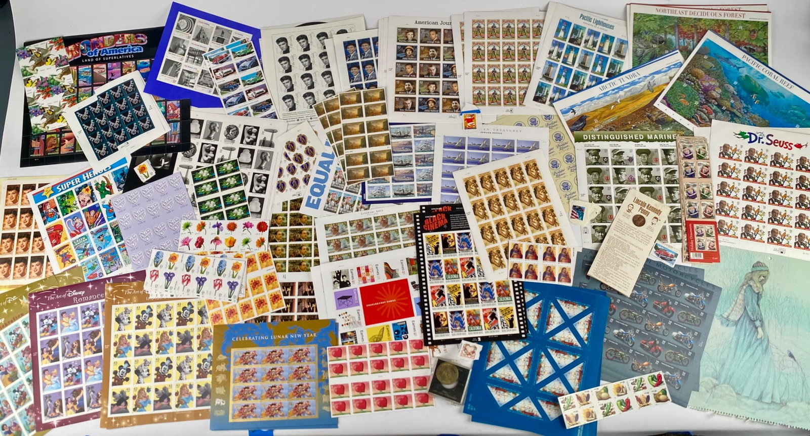 Collection of U.S. Commemorative Stamp Sheets and Related Ephemera: Extensive collection of United States postage stamp sheets, including themes such as Disney, Dr. Seuss, American history, distinguished Americans, celebrations of equality, and artistic depictions. Ma