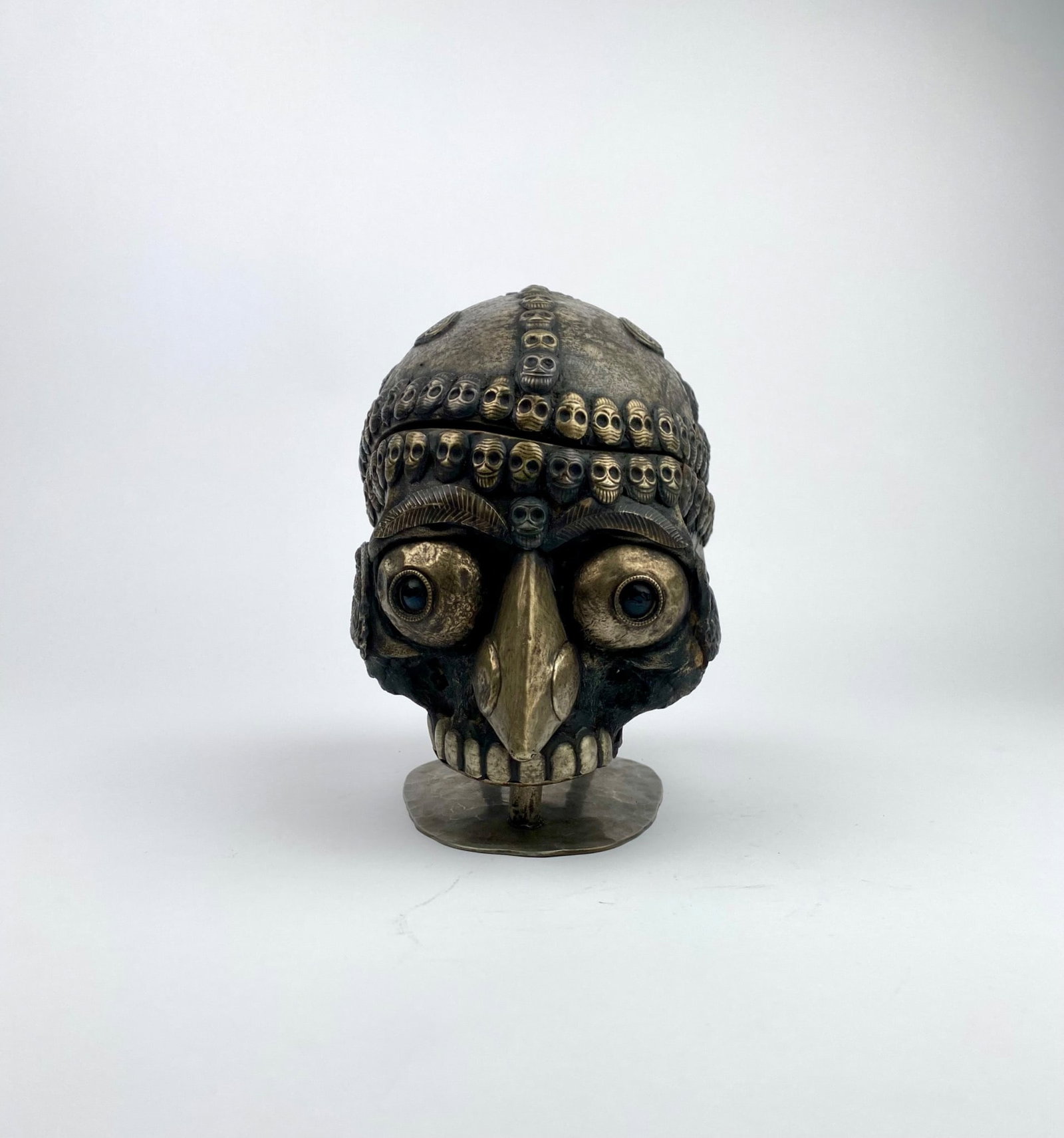 Tibetan Kapala Skull with Silver Detailing and Hinged Lid: Tibetan Kapala skull with a hinged lid, featuring intricate silver detailing, including rows of skull motifs, ornate patterns, and small removable pieces. The base provides stability. The interior sho
