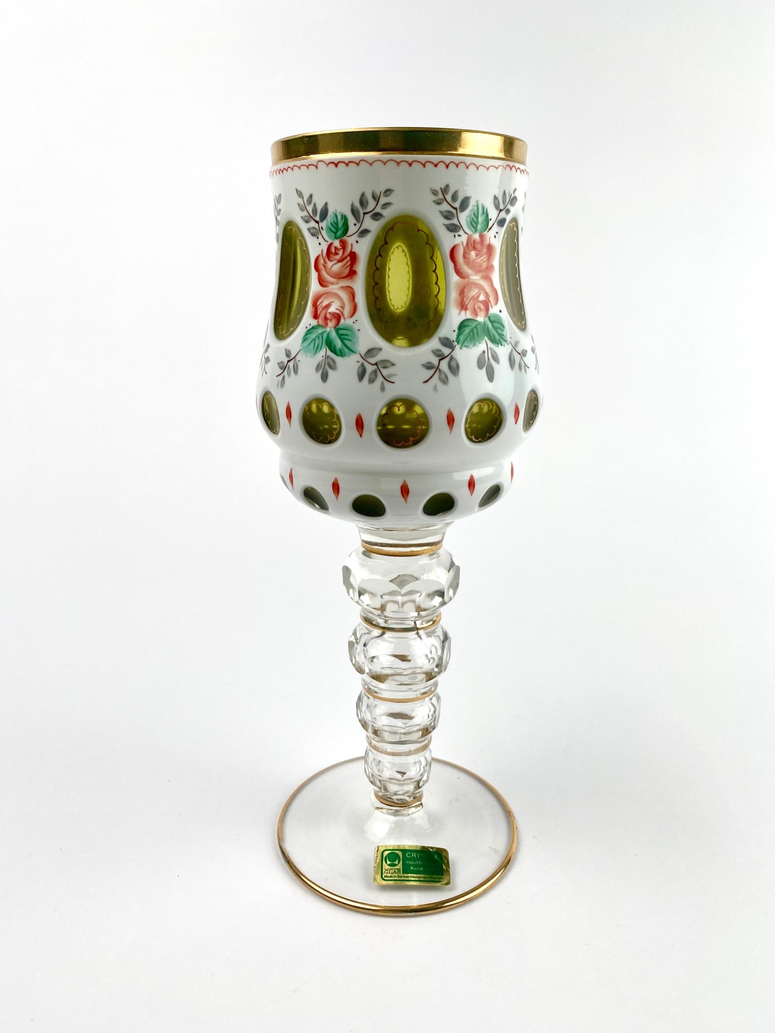 Czech Bohemian Crystal Wine Glass with Gilt and Floral Decoration: Czech Bohemian mouth-blown, hand-cut crystal wine glass featuring a decorative design with gilt accents, floral motifs, and green cut-to-clear panels. The glass includes a faceted stem with gold accen